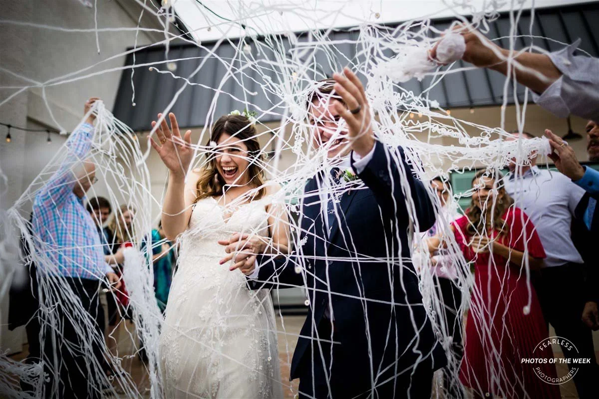 Bride and groom push through crazy paper streamer wedding exit