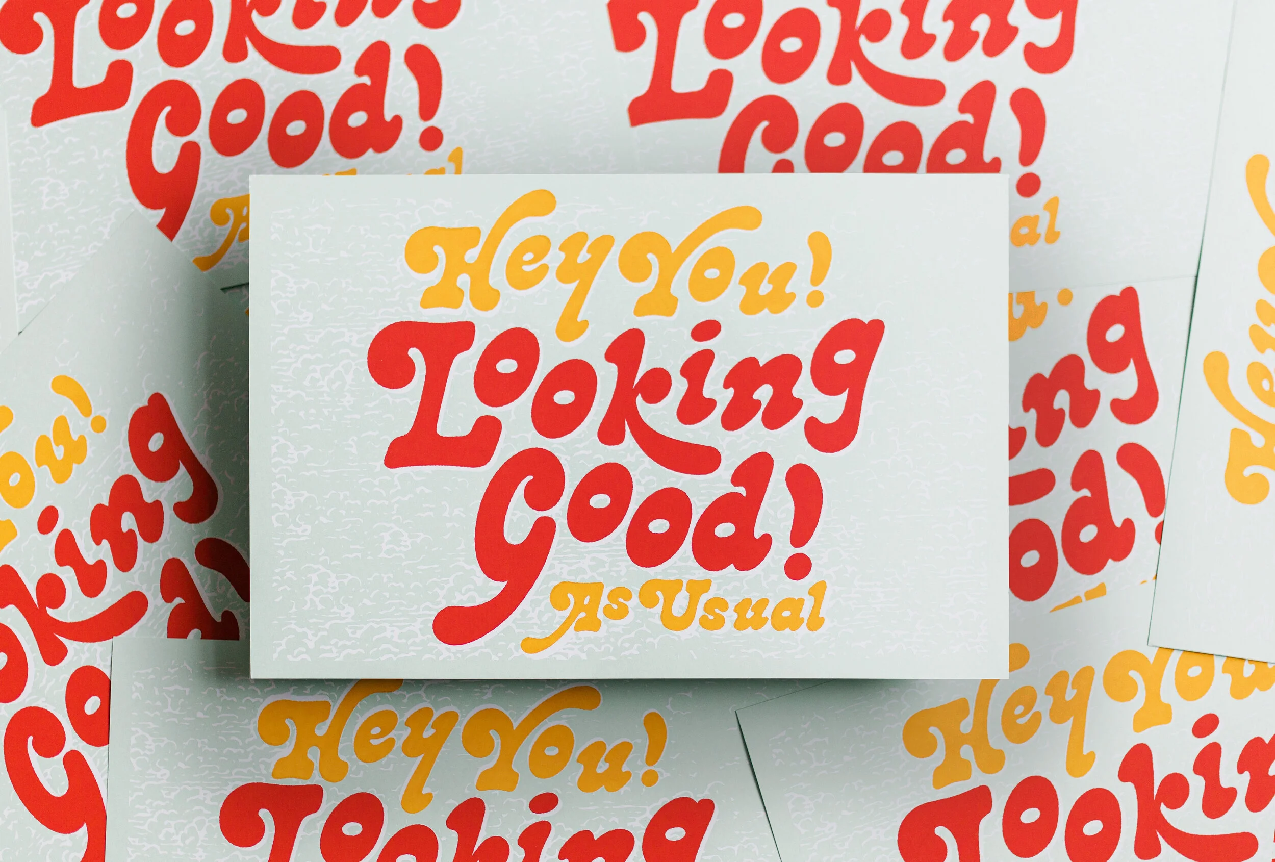 Multiple cards with a white background and colorful text that says, "Hey You! Loving good! is usual" in red and yellow letters.