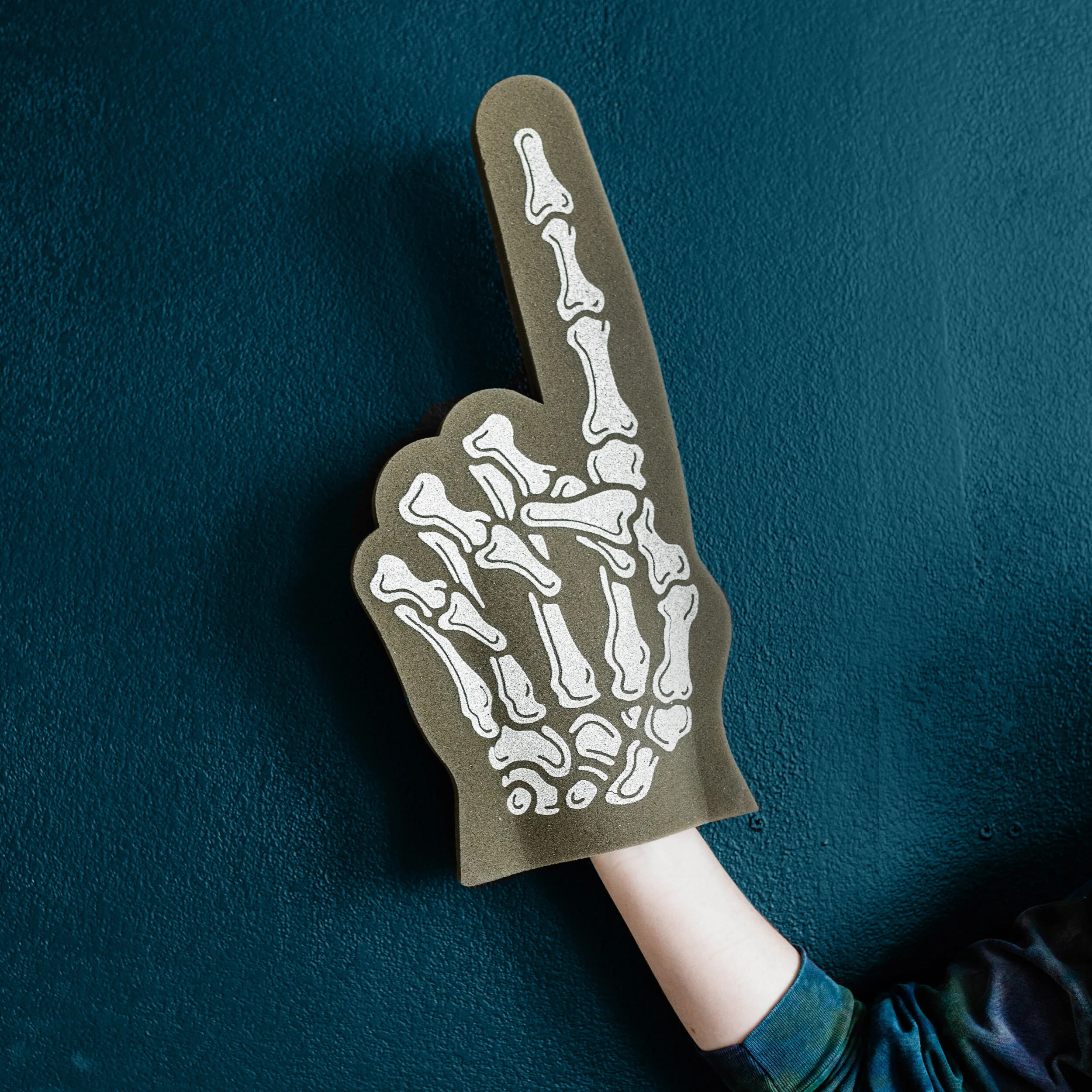 A foam hand in the shape of a skeletal hand making a peace sign, set against a dark teal background.