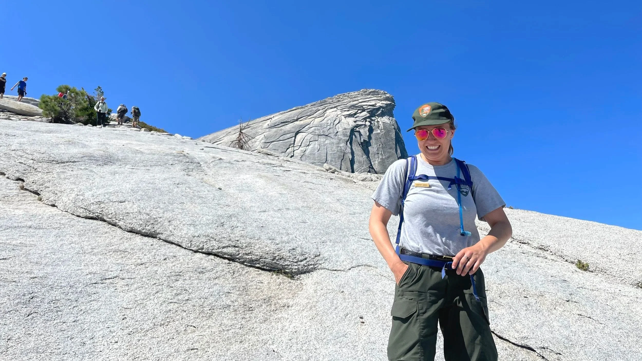 A park ranger poses near the top of Half Dome in Yosemite.
