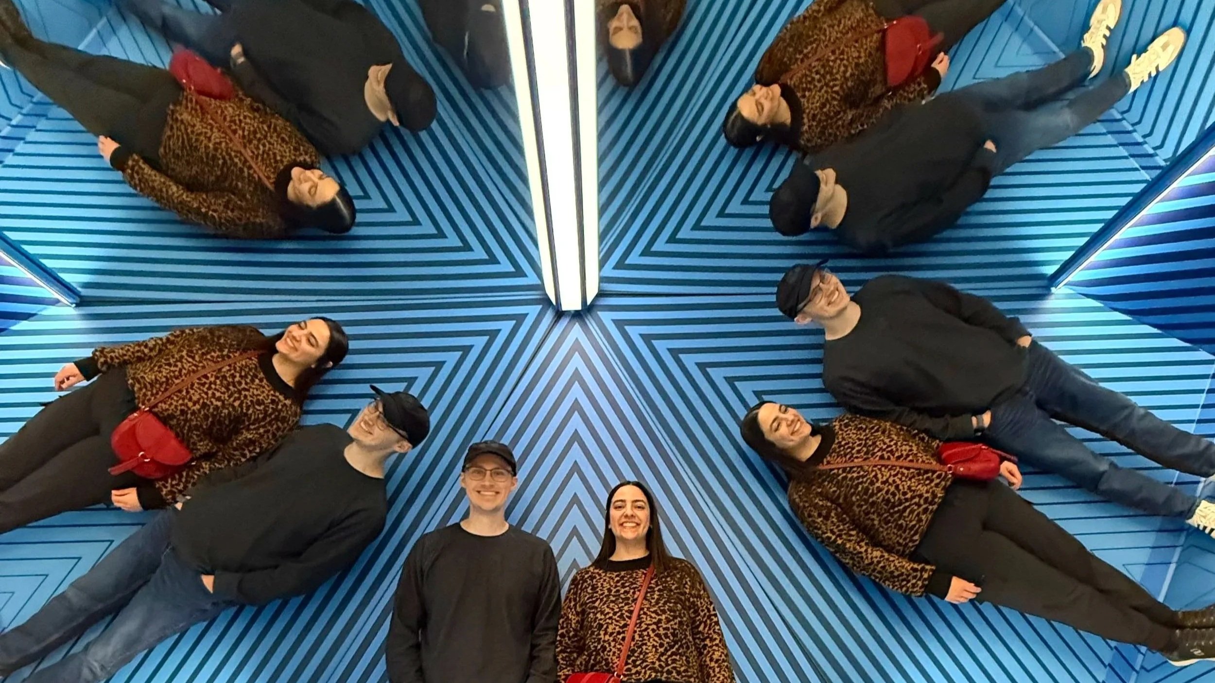 A mirror illusion duplicates a couple at the Museum of Ilusions.