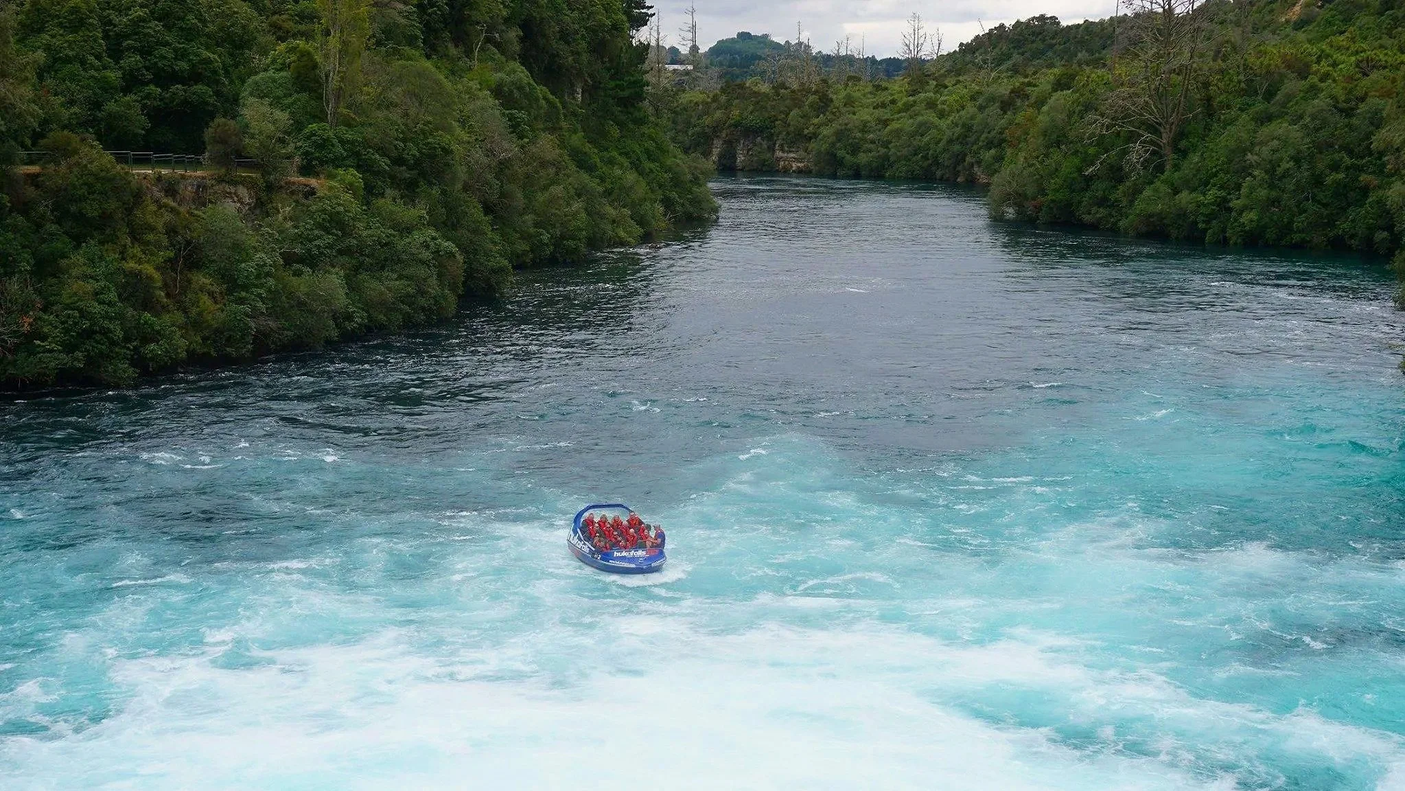 A jetboat rides up close to rapids at Huka Falls in New Zealand