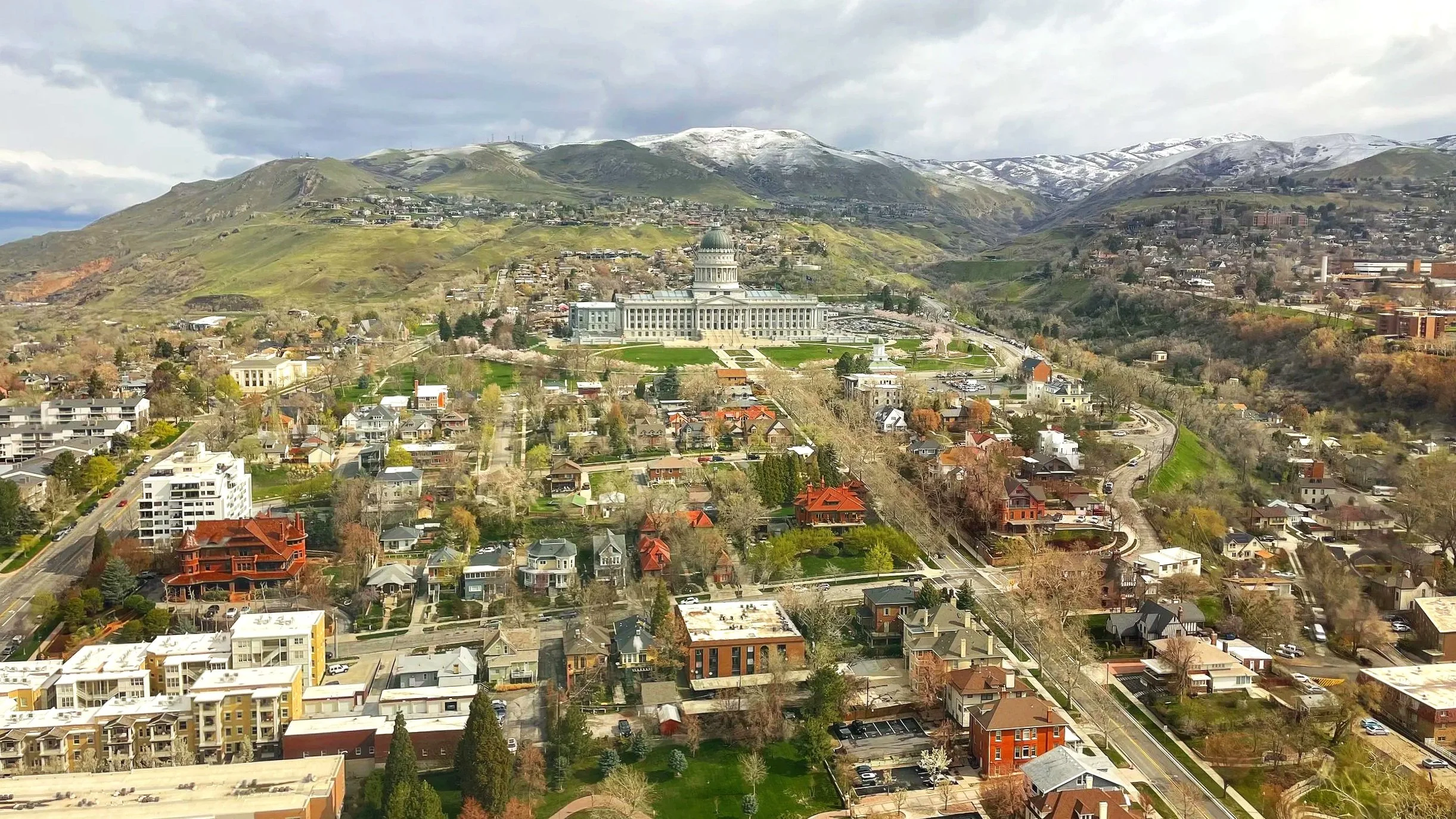 Dowtown Salt Lake City, with a view of the state capitol building and surrounding neighborhoods; snow-capped mountains are seen in the background.