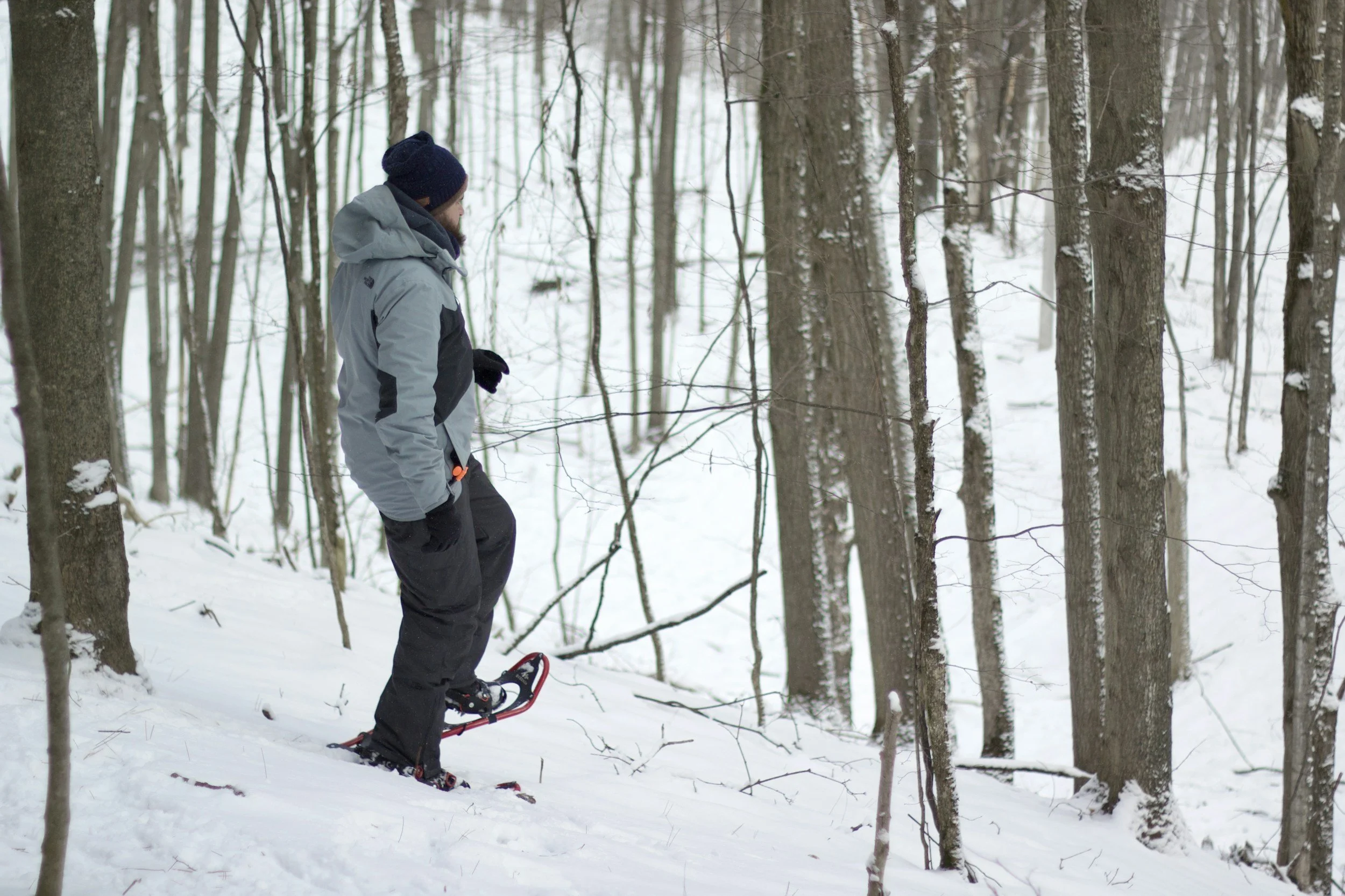 A man is snowshoeing in the snowy mountains