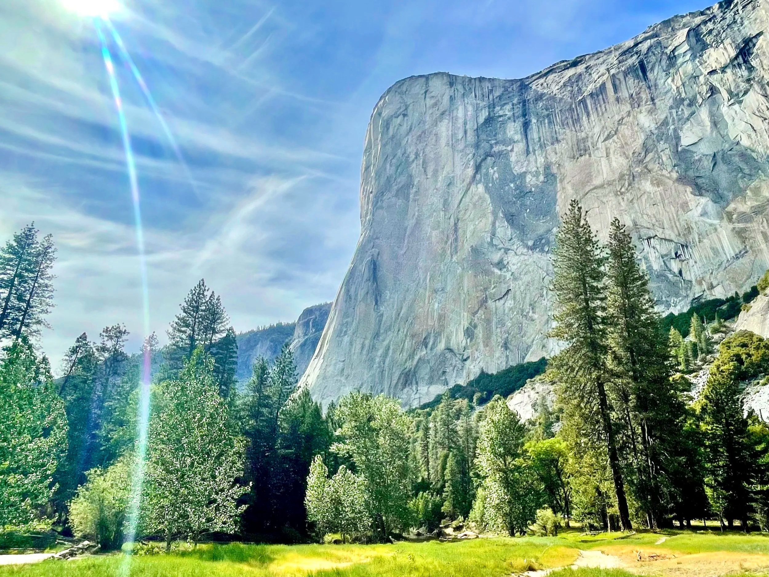 Sun rays fill Yosemite Valley next to a view of El Capitan.
