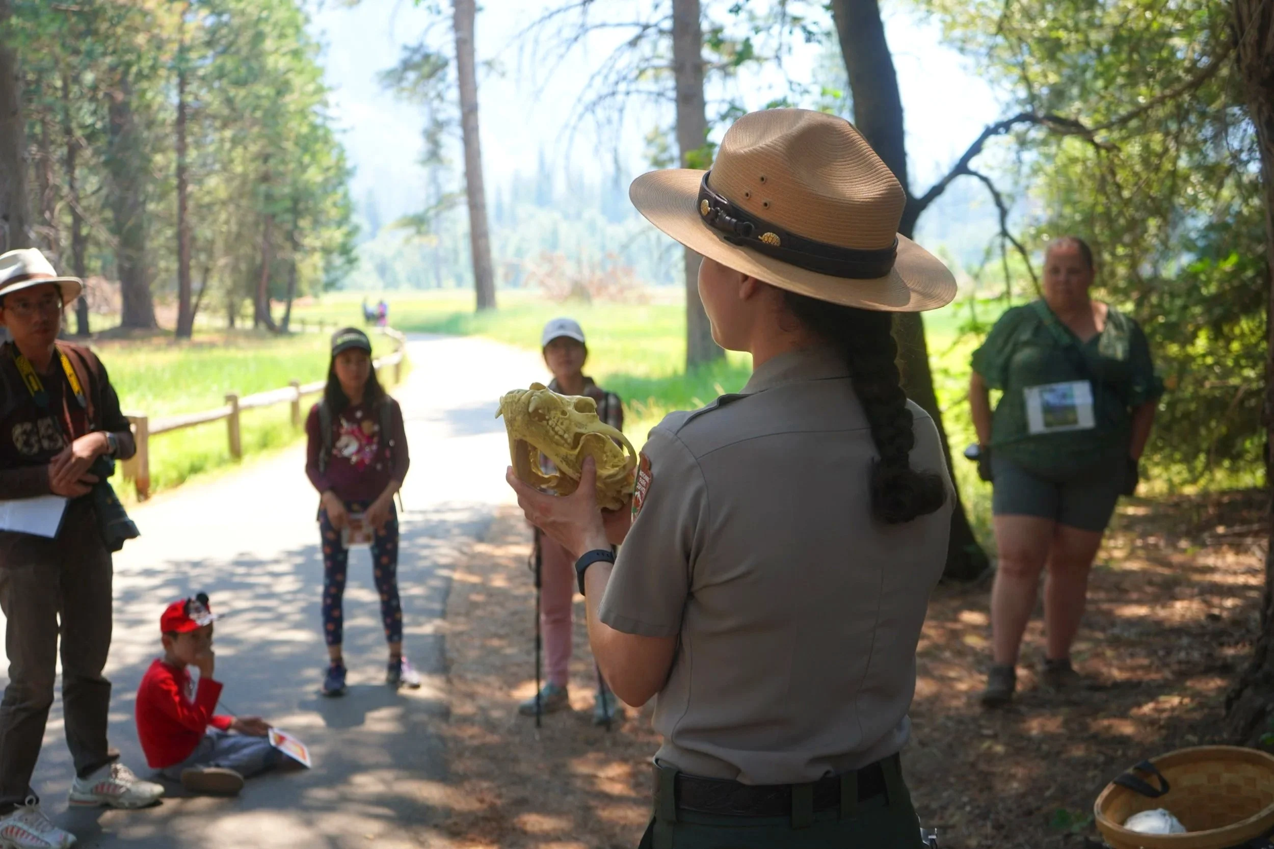A park ranger holds up an animal skull during a ranger program in Yosemite.