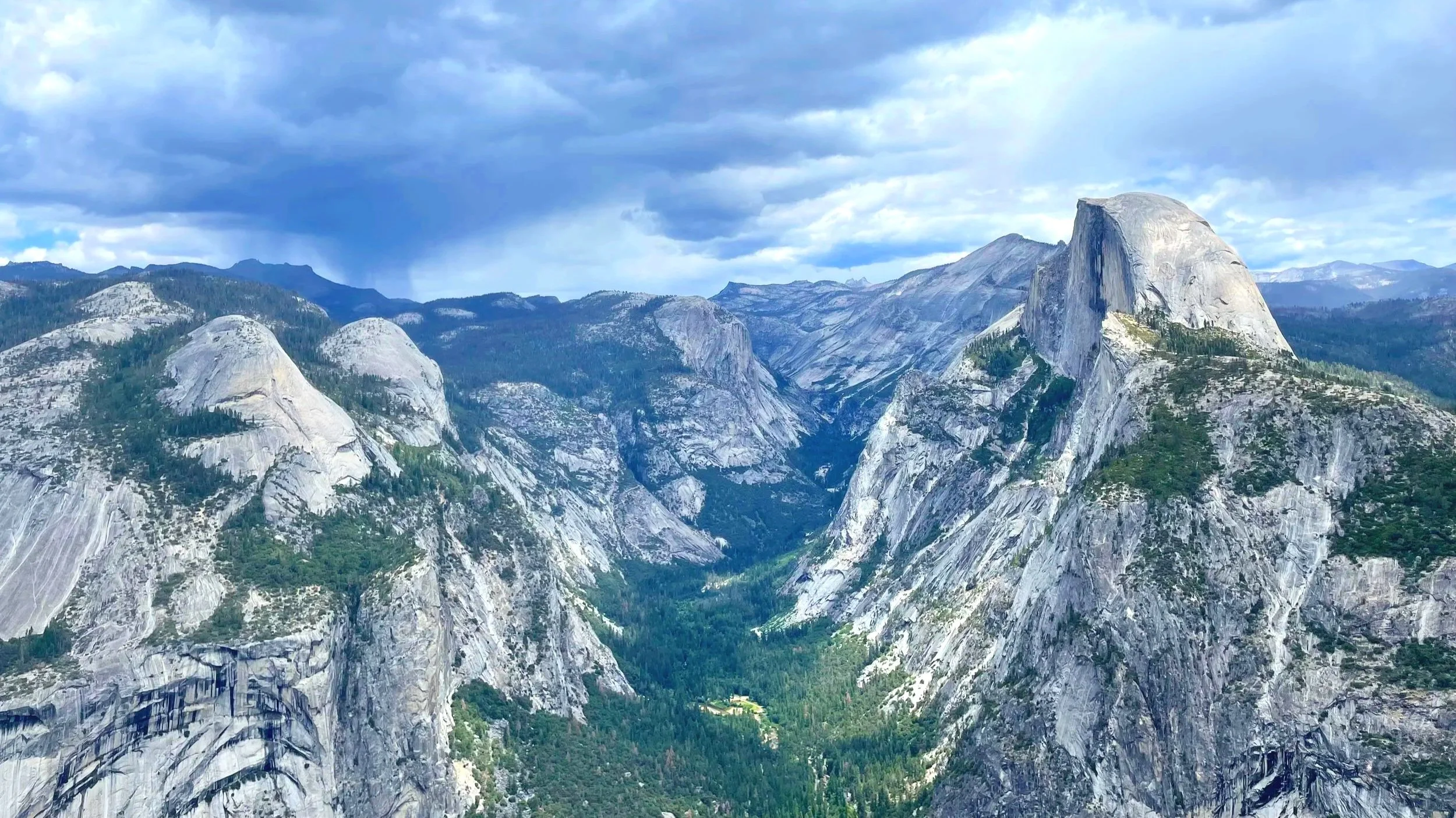 Yosemite Valley from a bird's eye view, with a green valley surrounded by granite mountain peaks.