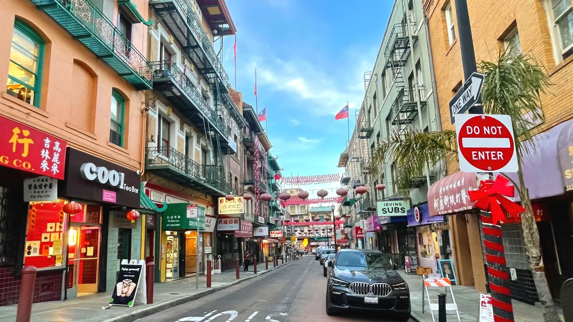 A narrow street in San Francisco between tall and colorful buildings.