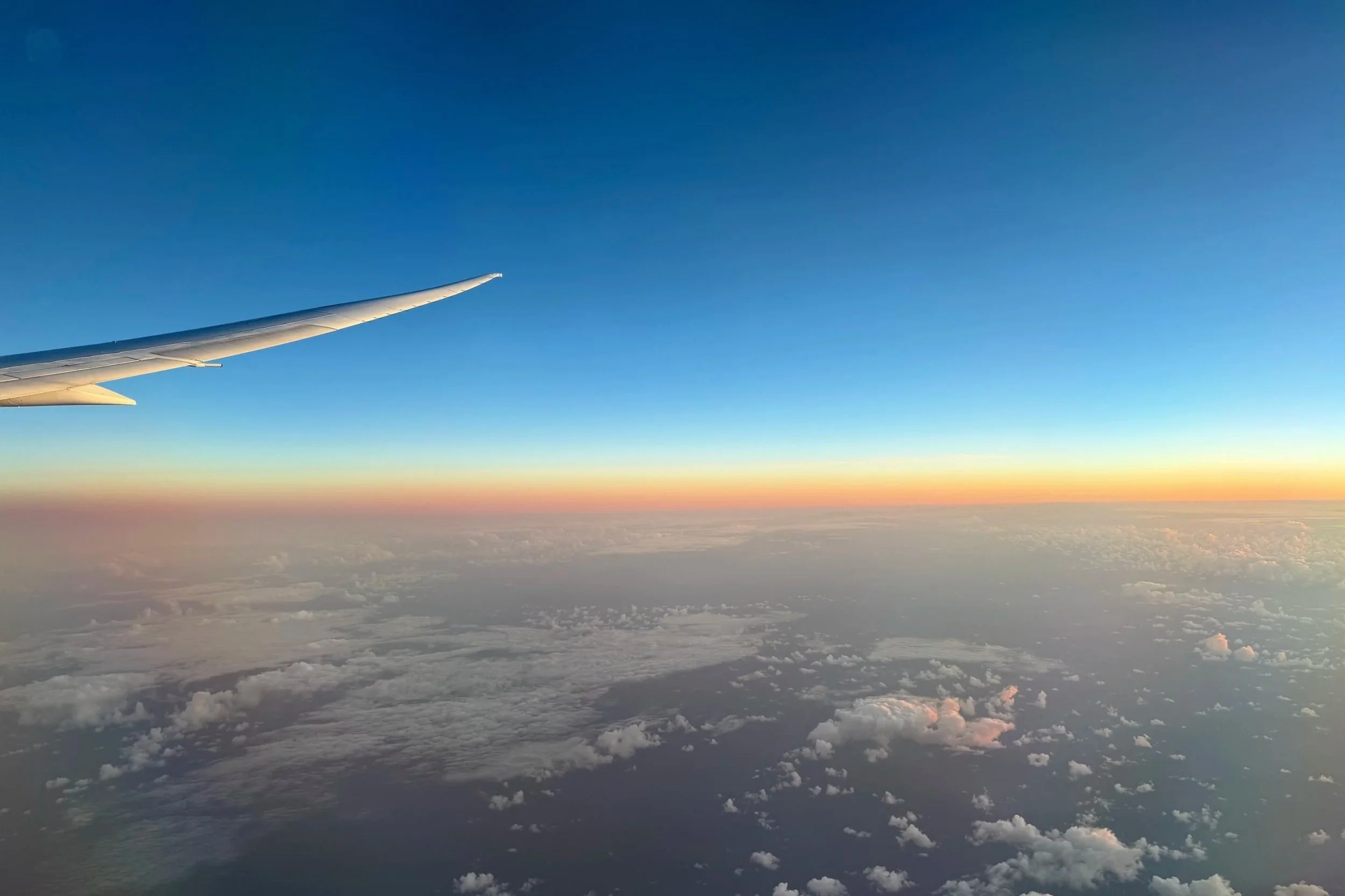 The sunset lit horizon is seen in the distance from an airplane in the US.