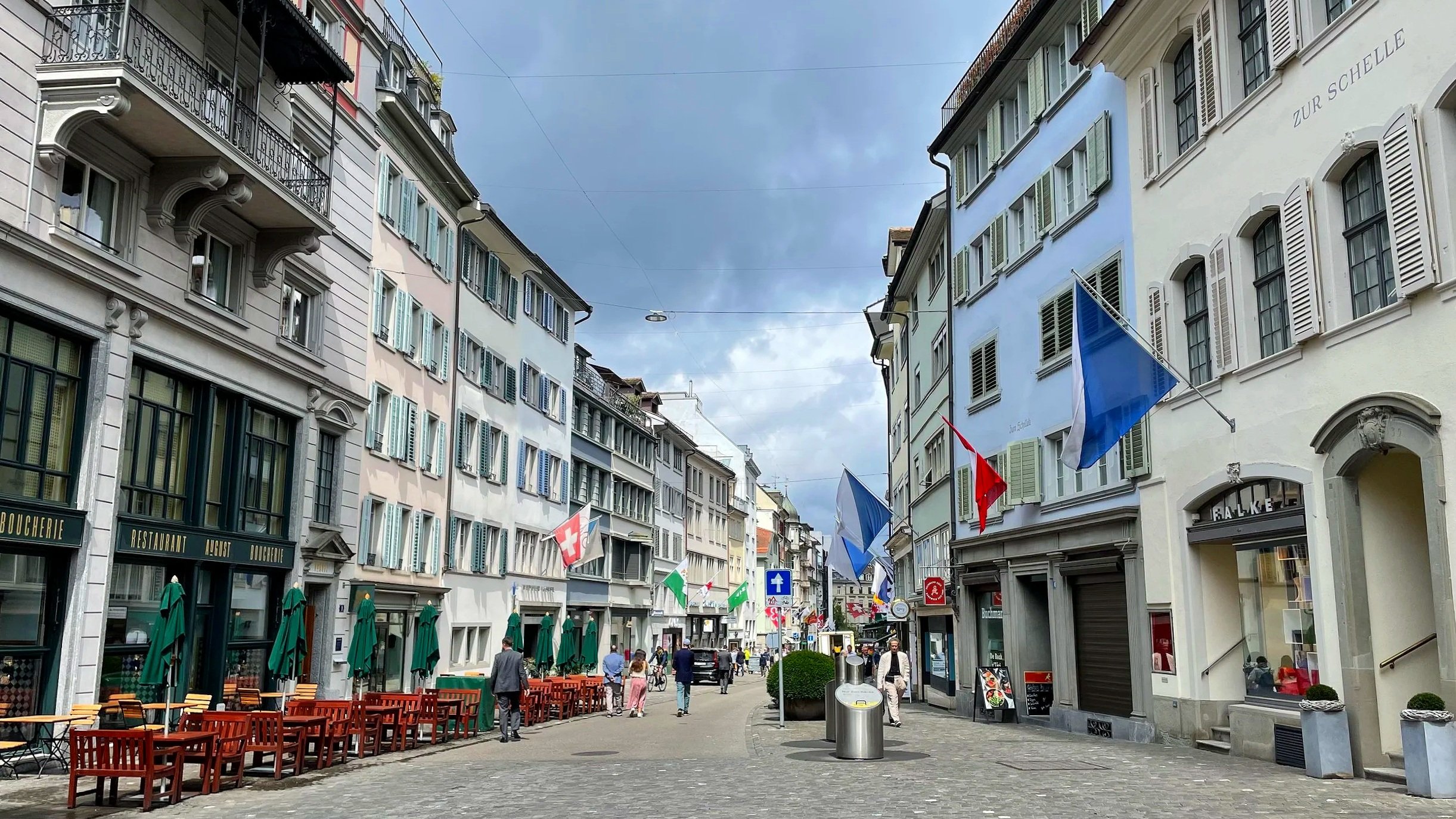 A street in Zurich is lined with flags and charming buildings.