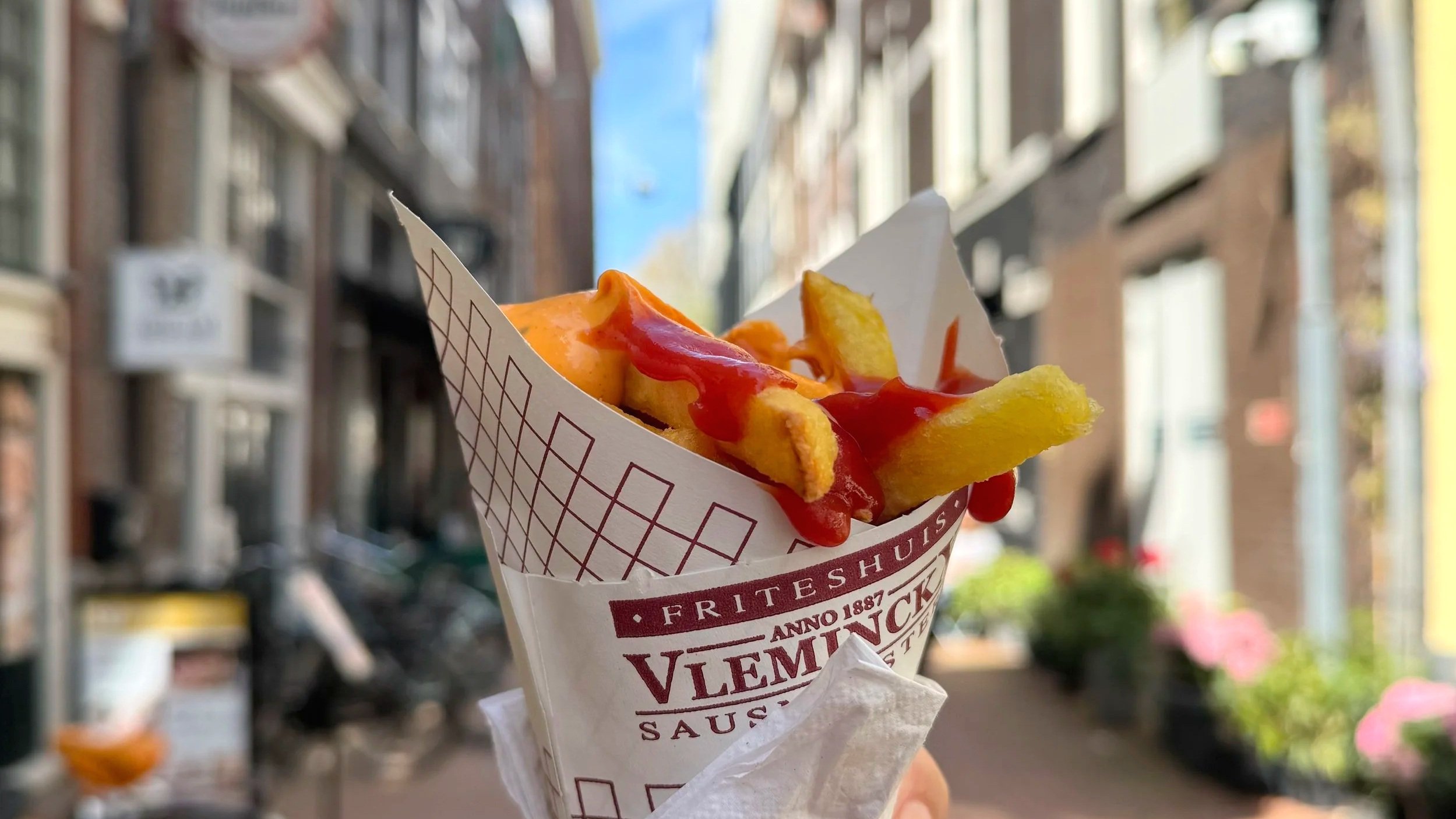 Friets in a cone smothered with sauce, seen in an alley in Amsterdam