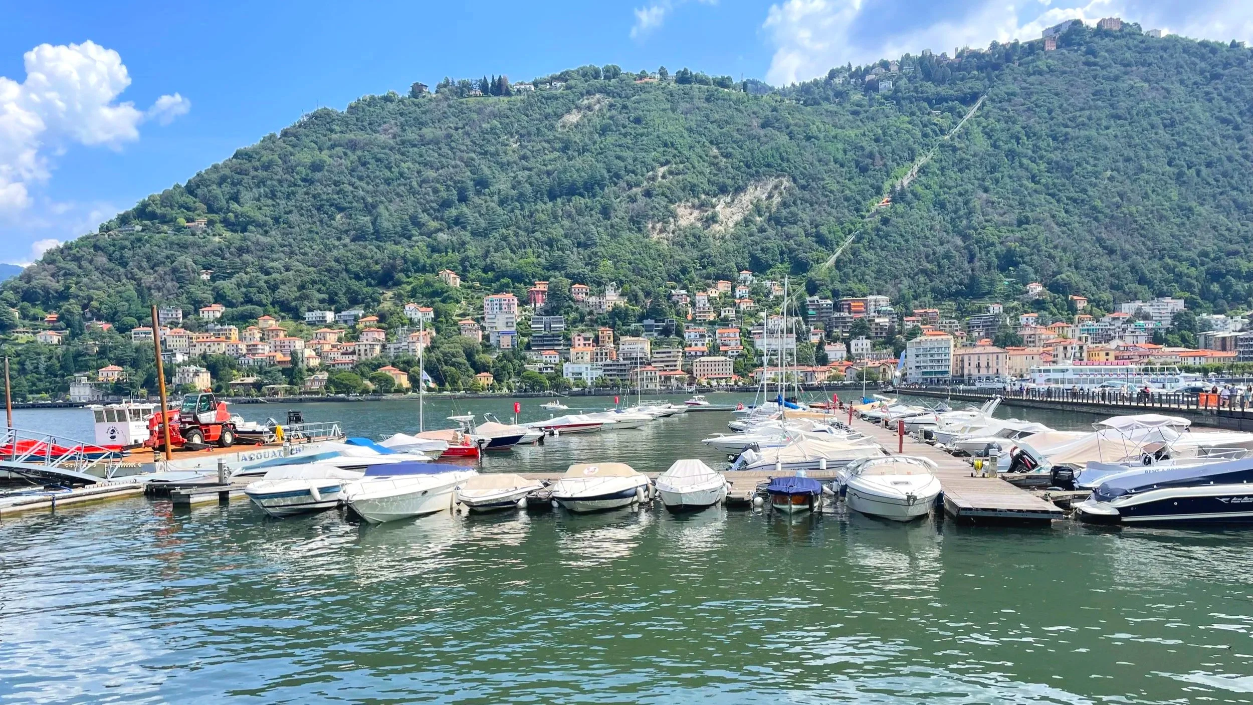 A marina on Lake Como can be seen from the shores of Como
