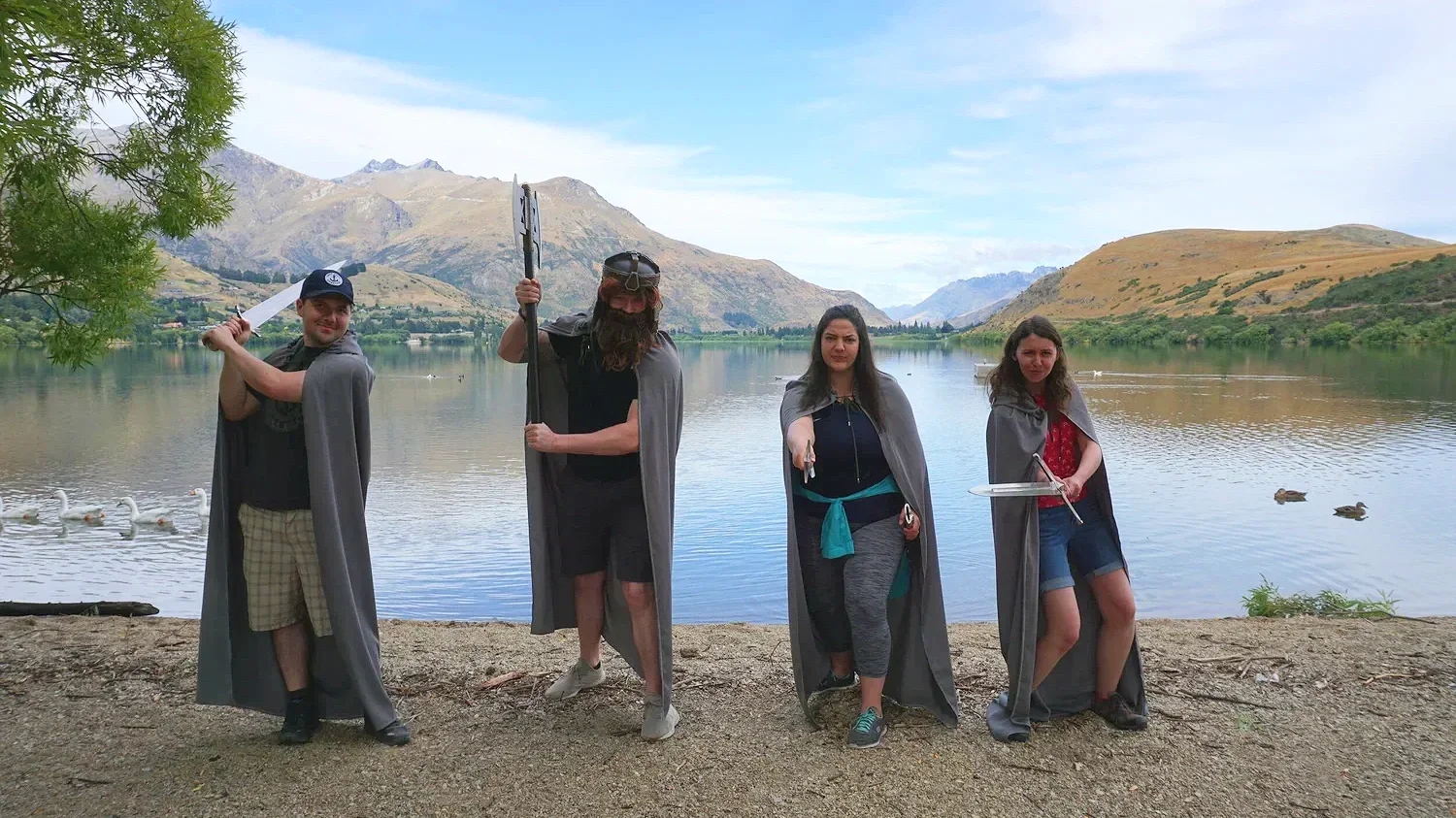 People dressed up in Lord of the Rings costumes posed in front of a Queenstown lake.