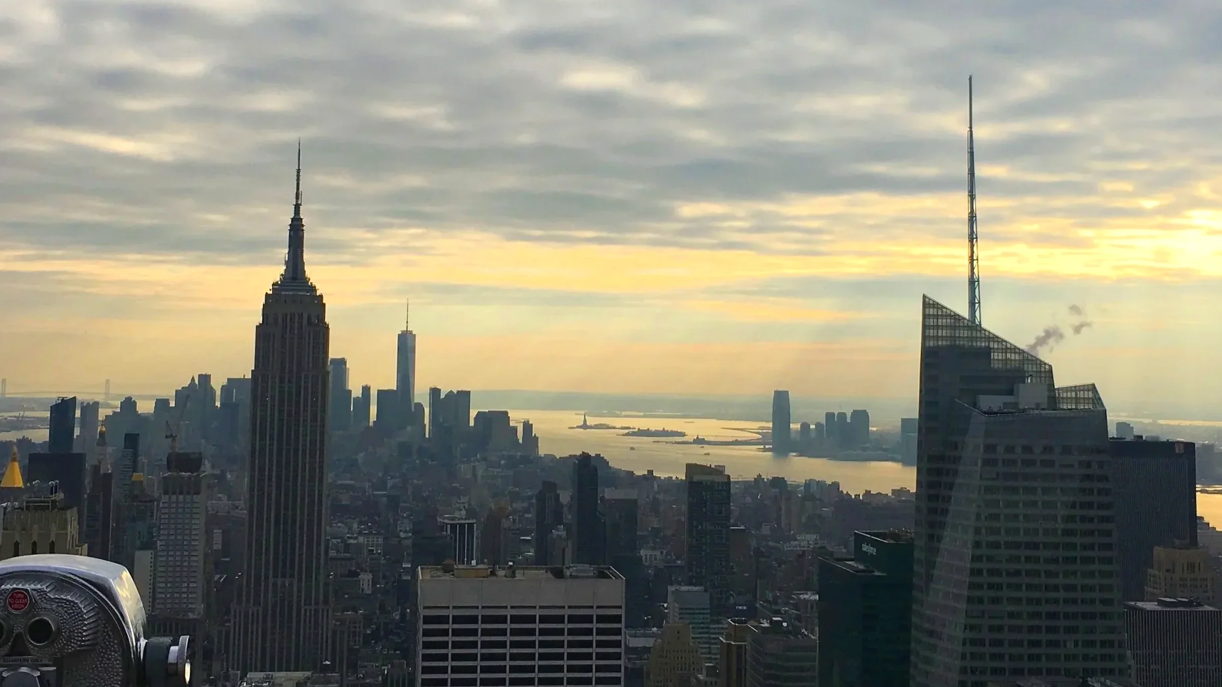 New York skyline with a view of the Statue of Liberty in the distance.