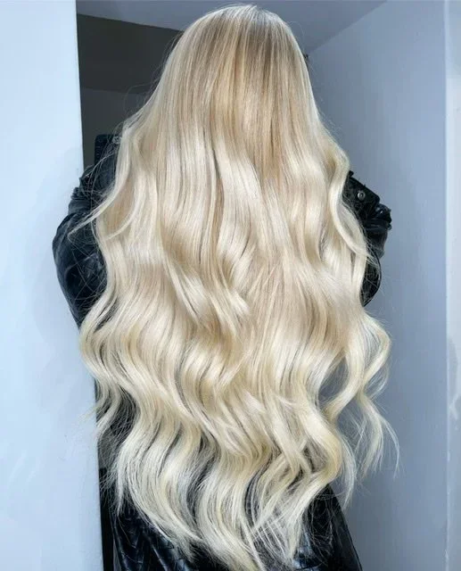 Pitkät vaaleat hiukset hiustenpidennysten lopputuloksena Hair Design Helsingissä