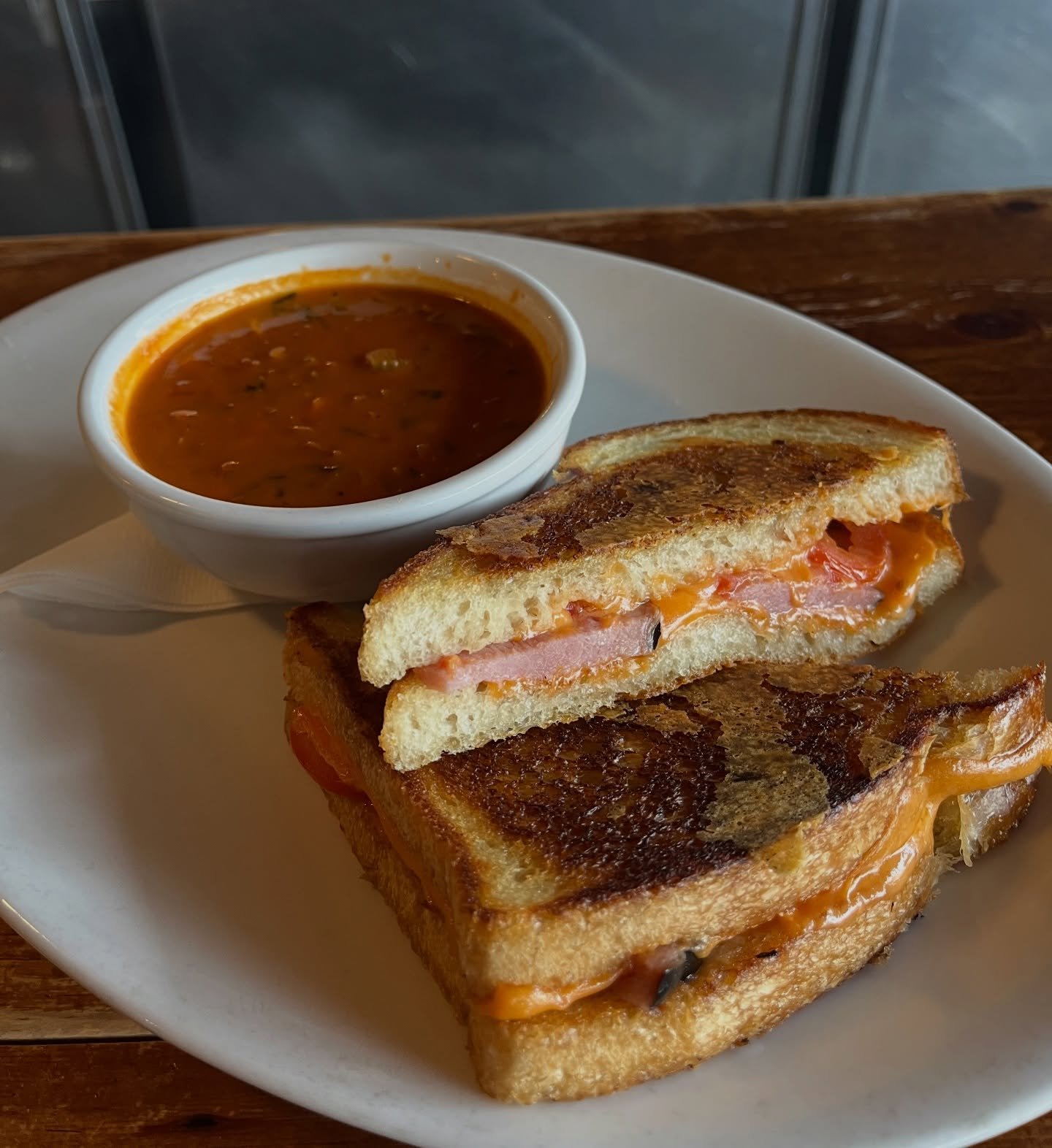 Deluxe Grilled Cheese (Secret Menu Item)
Ham, cheese, tomato, and garlic basil butter on sourdough. Best enjoyed when our soup of the day is Tomato Basil🌿