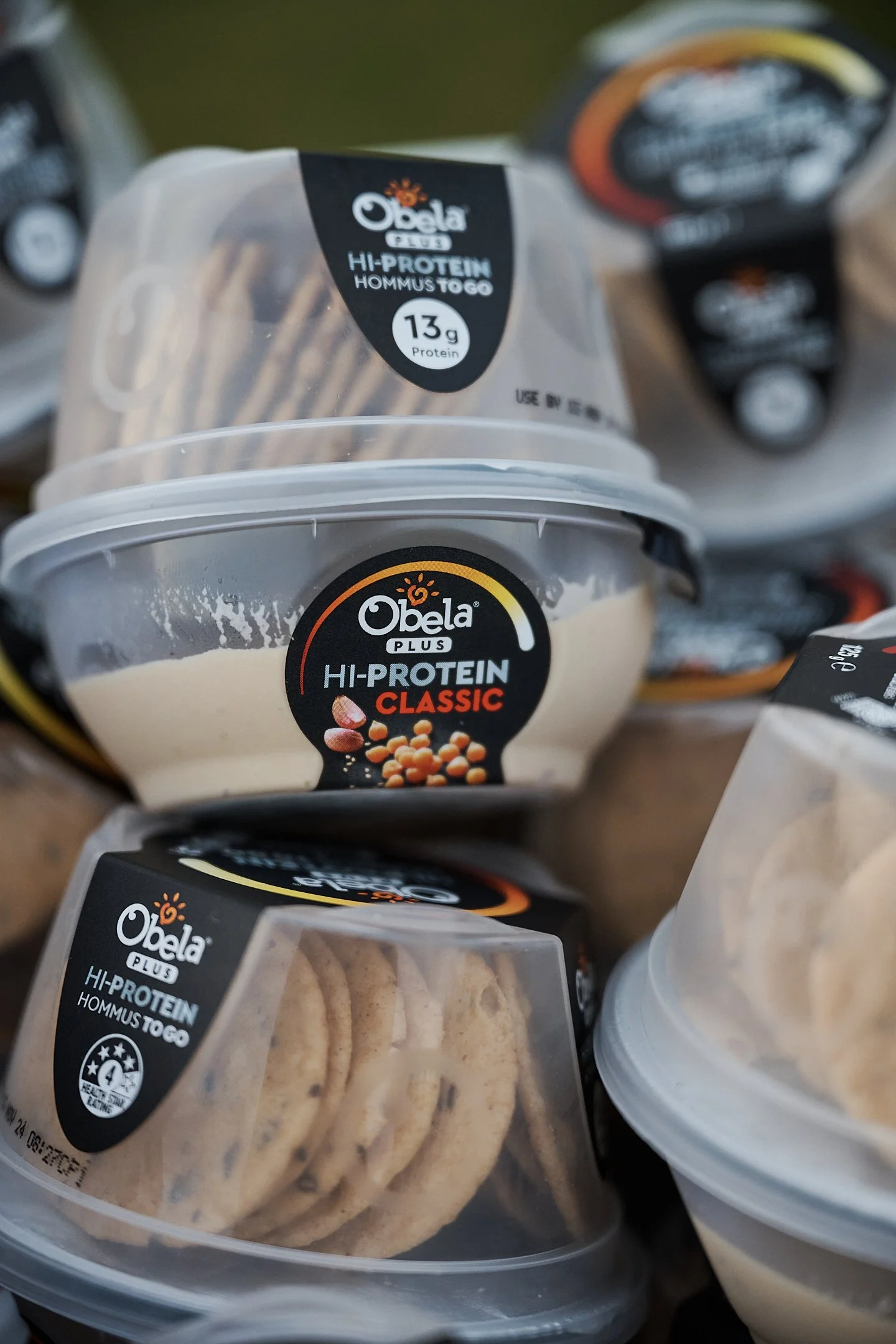 Containers of Obela Plus high-protein hummus and crackers.