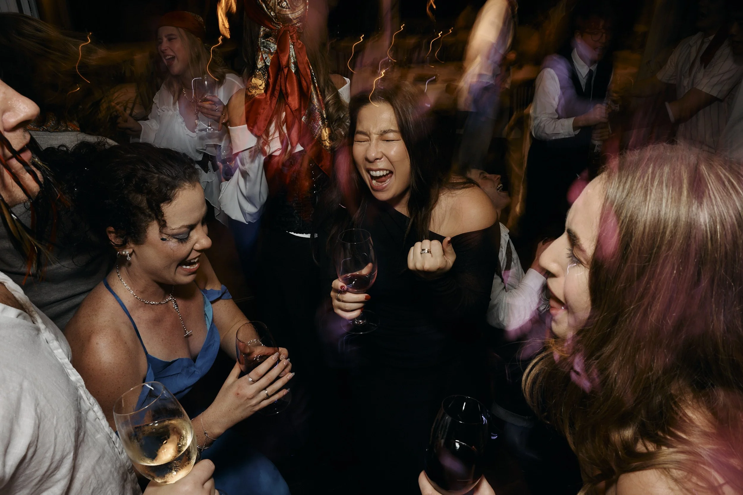 light trails show movement and excitement as people sing passionately along to a song at a party