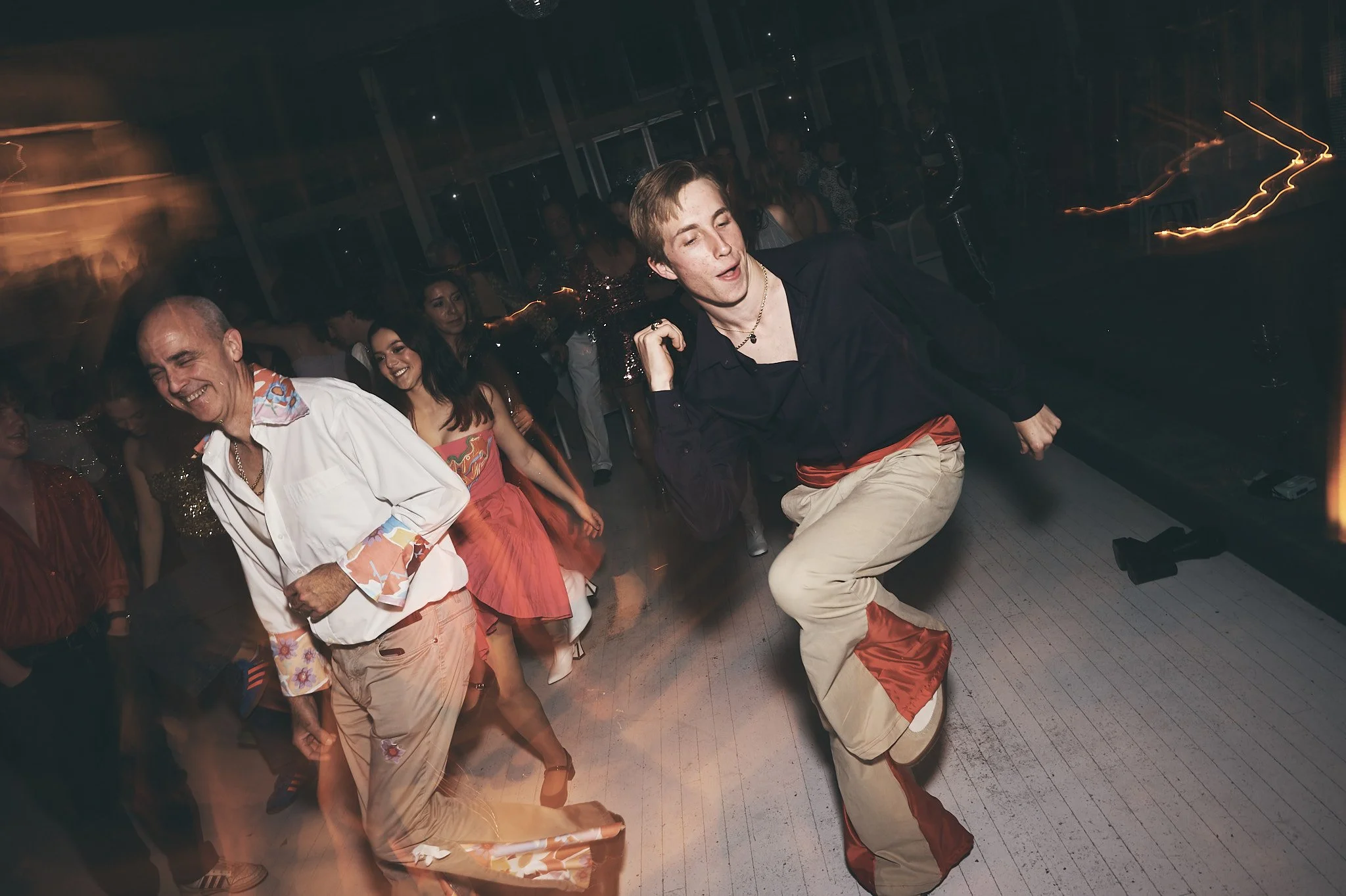 People dancing and having fun at a party or celebration in a dimly lit room.