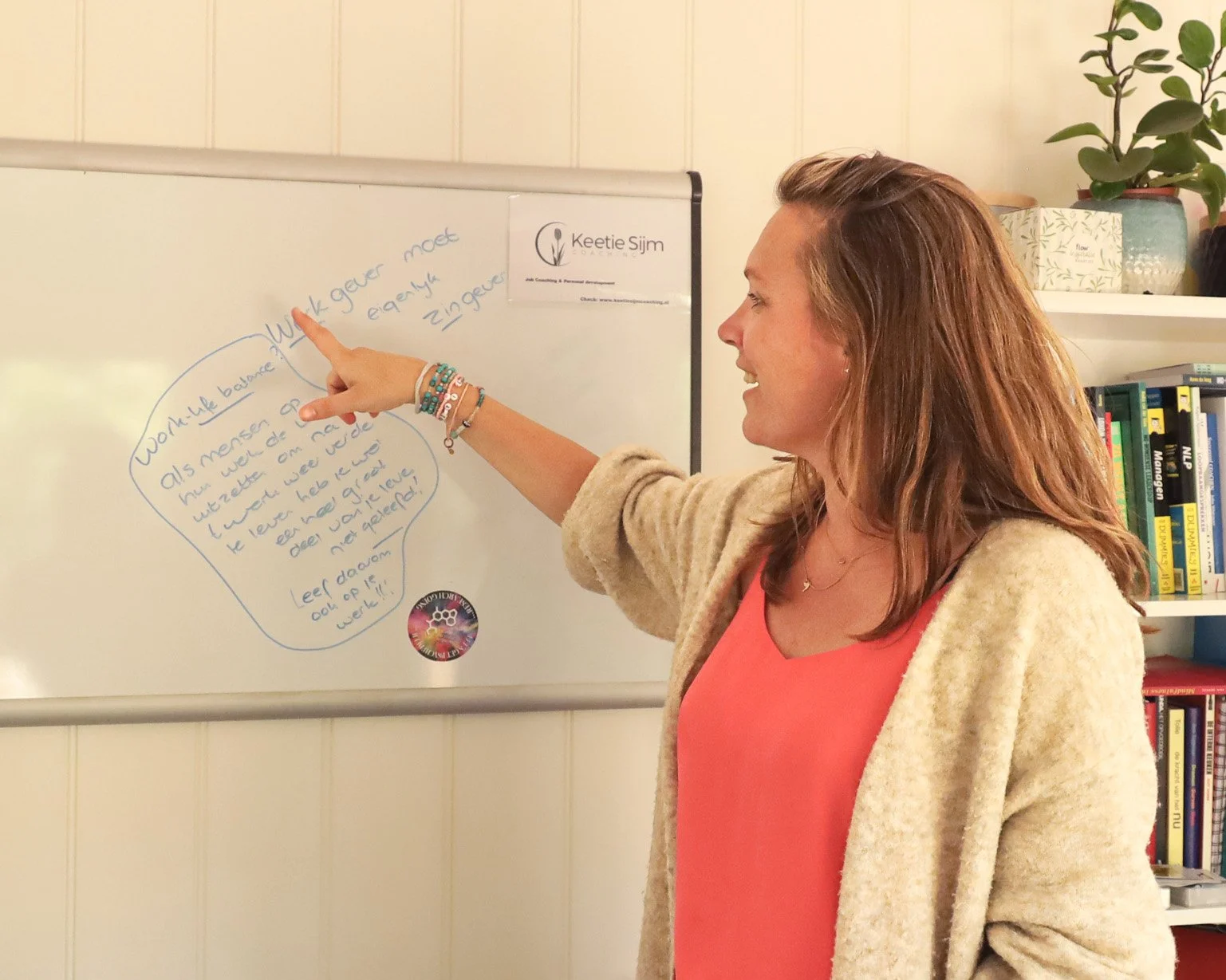 Keetie Sijm die een groep professionals begeleidt tijdens een training over samenwerking en communicatie.