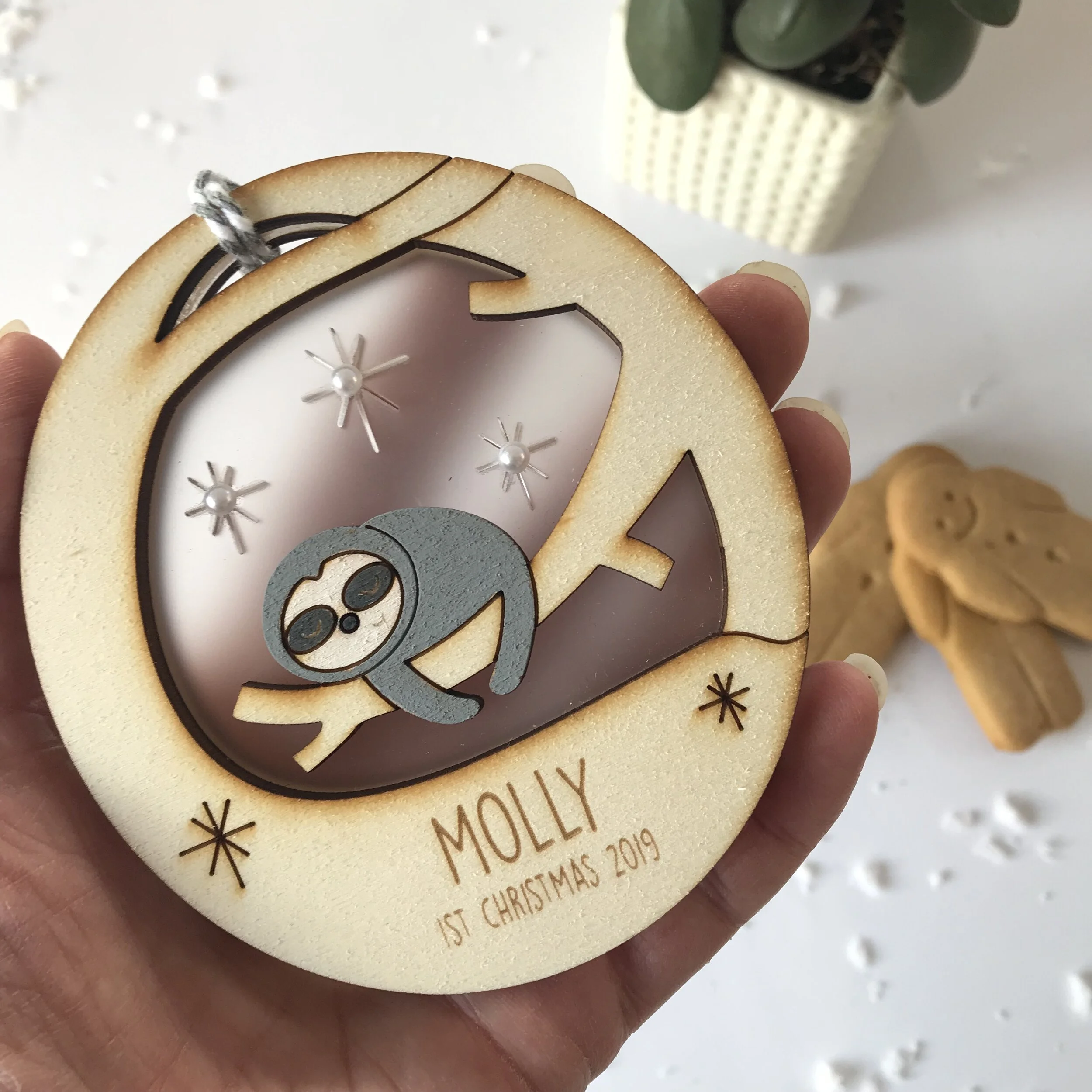 Baby sloth christmas bauble in hand