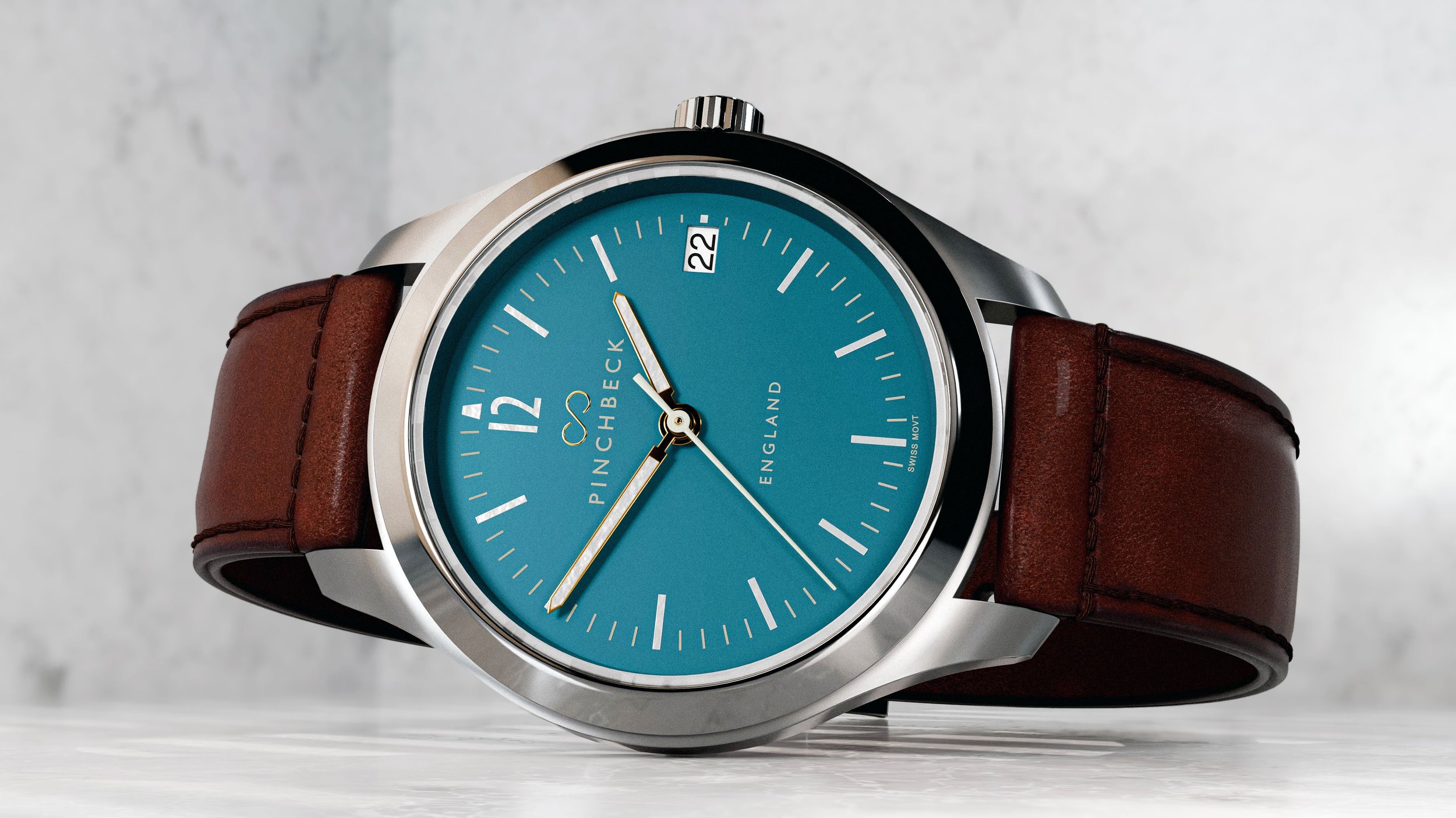 A Harold Pinchbeck Sigma wristwatch with a teal face, brown leather strap, and silver case showing the time as 11:39, with a date display showing the 22nd.