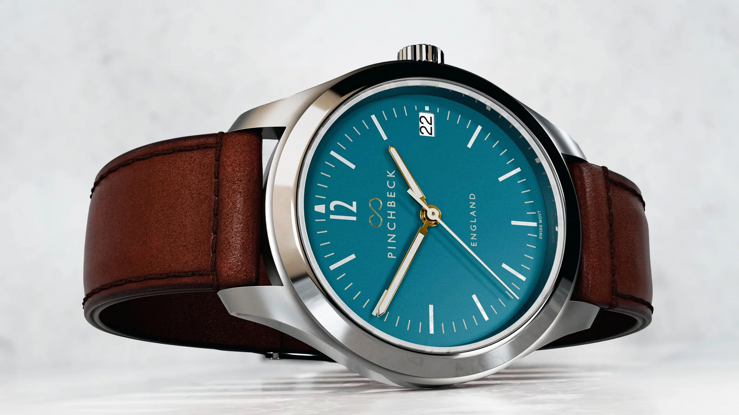 A Harold Pinchbeck Sigma wristwatch with a teal dial, brown leather strap, silver case, gold hands, and a date window showing the 22nd.