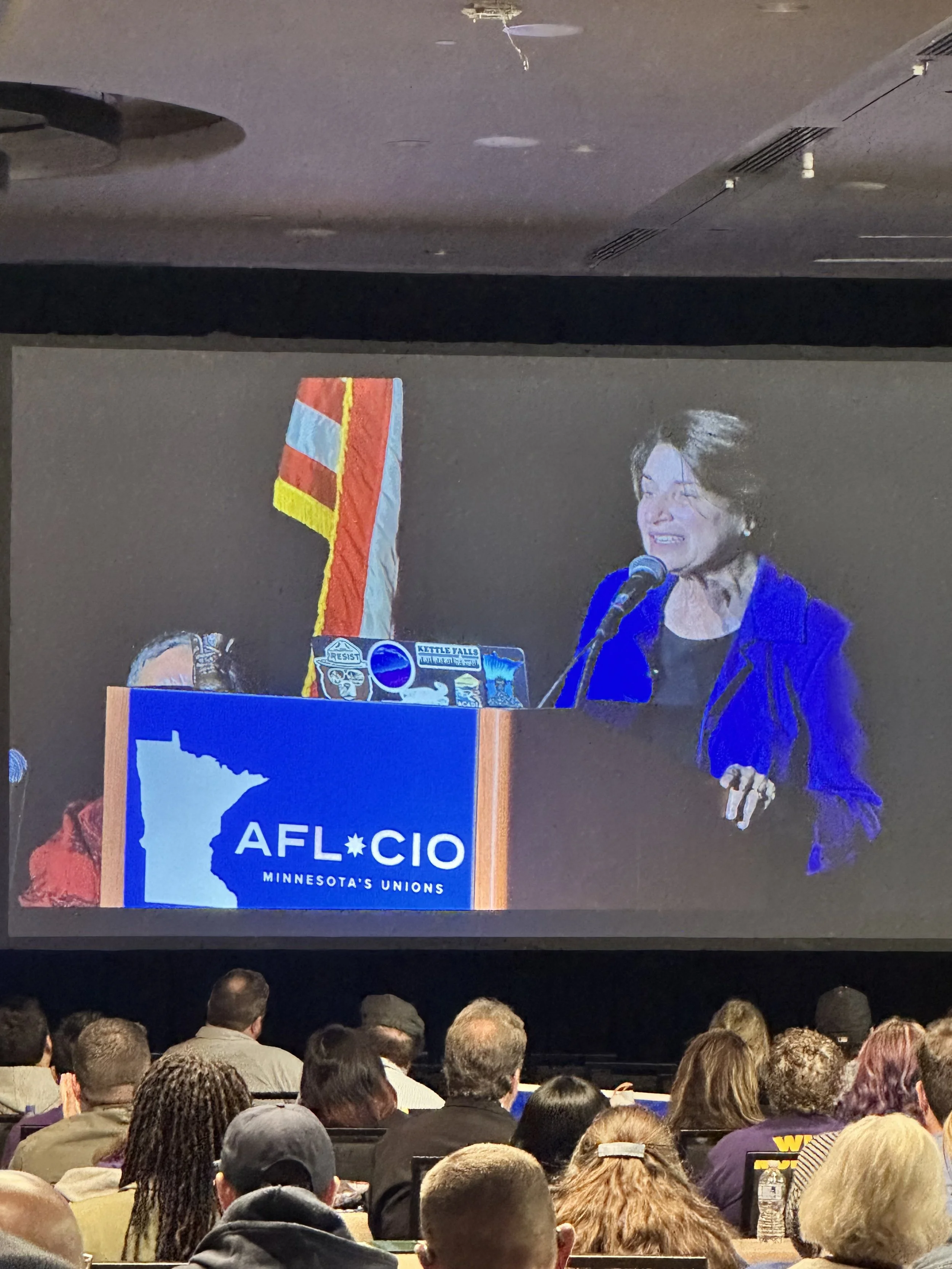 Amy Klobuchar with the boot! The art travelled to the MN AFL-CIO convention in September 2026, and they needed to use it as a gavel!