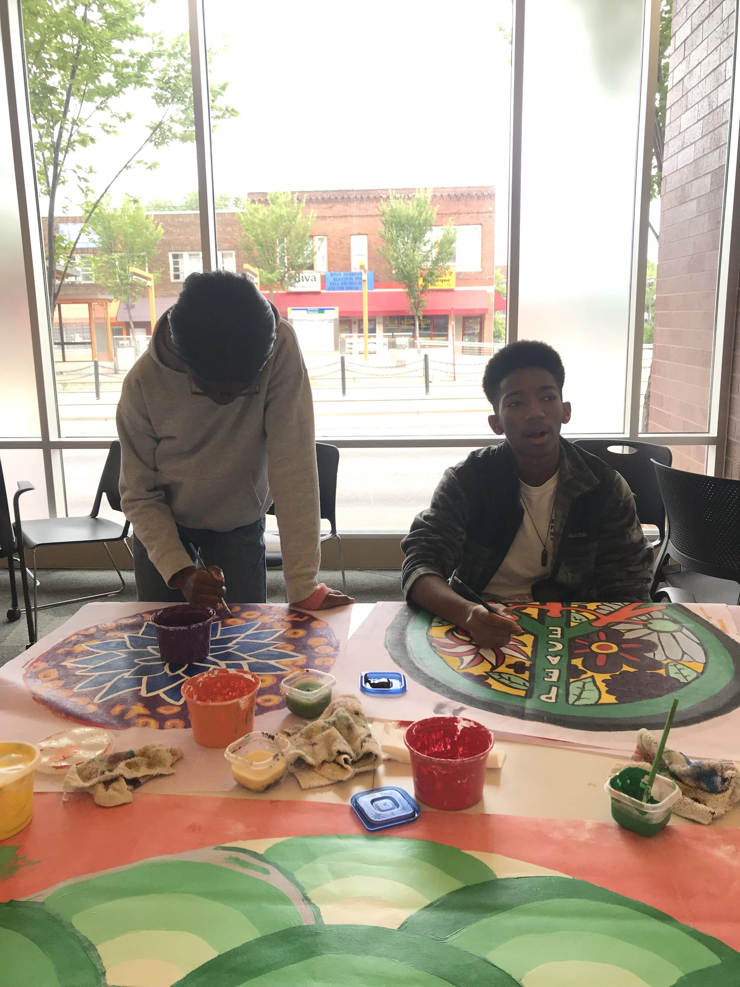 teen team touching up the community bubble murals