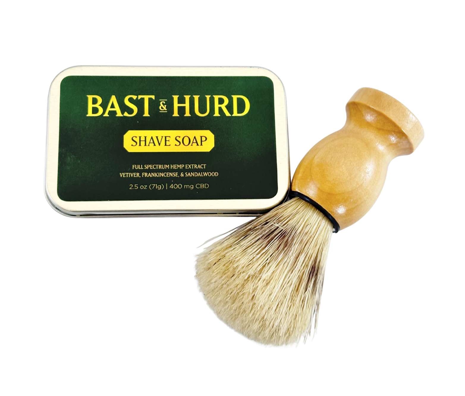 A tin of Bast & Hurd mens line shave soap at Pocono Organics with a shaving brush lying next to it.