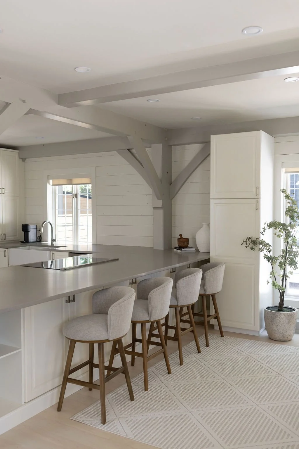 Large spacious chef's kitchen with four counter stools looking in at kitchen