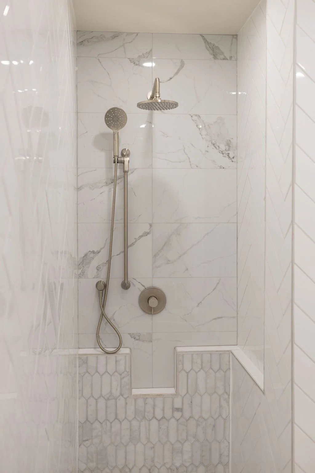 Spa shower with marble tiles, a rainfall showerhead, a handheld shower, and built-in bench seating in the master suite of The Ayrshire Laigh