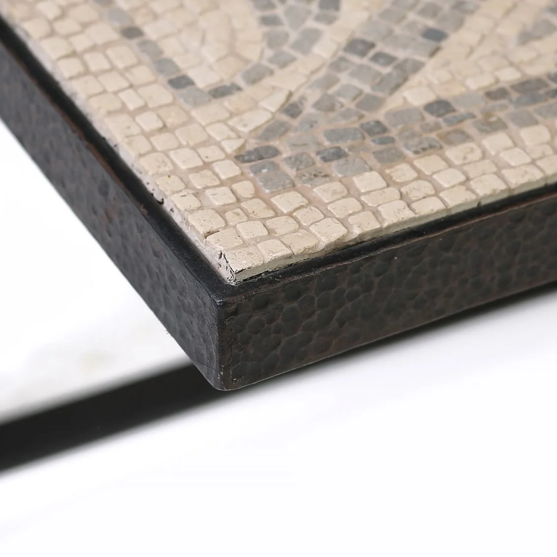 A closer look at the beauty of craftsmanship. The Pelta Tesserae Cocktail Table reveals an intricate mosaic of hand-laid tesserae framed by a richly textured edge&mdash;where material, detail, and design come together in quiet harmony. Proof that the