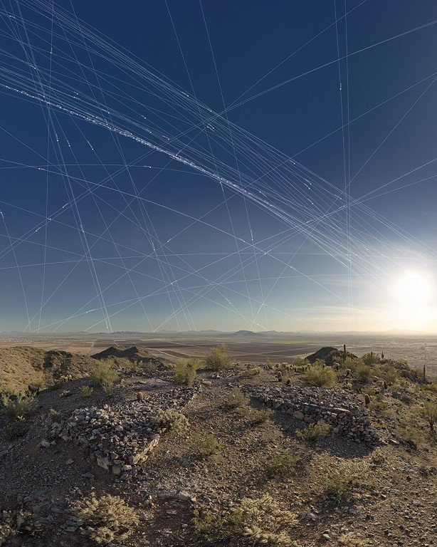  A web-like pattern streaks through the desert sky with concrete slabs in the foreground. 