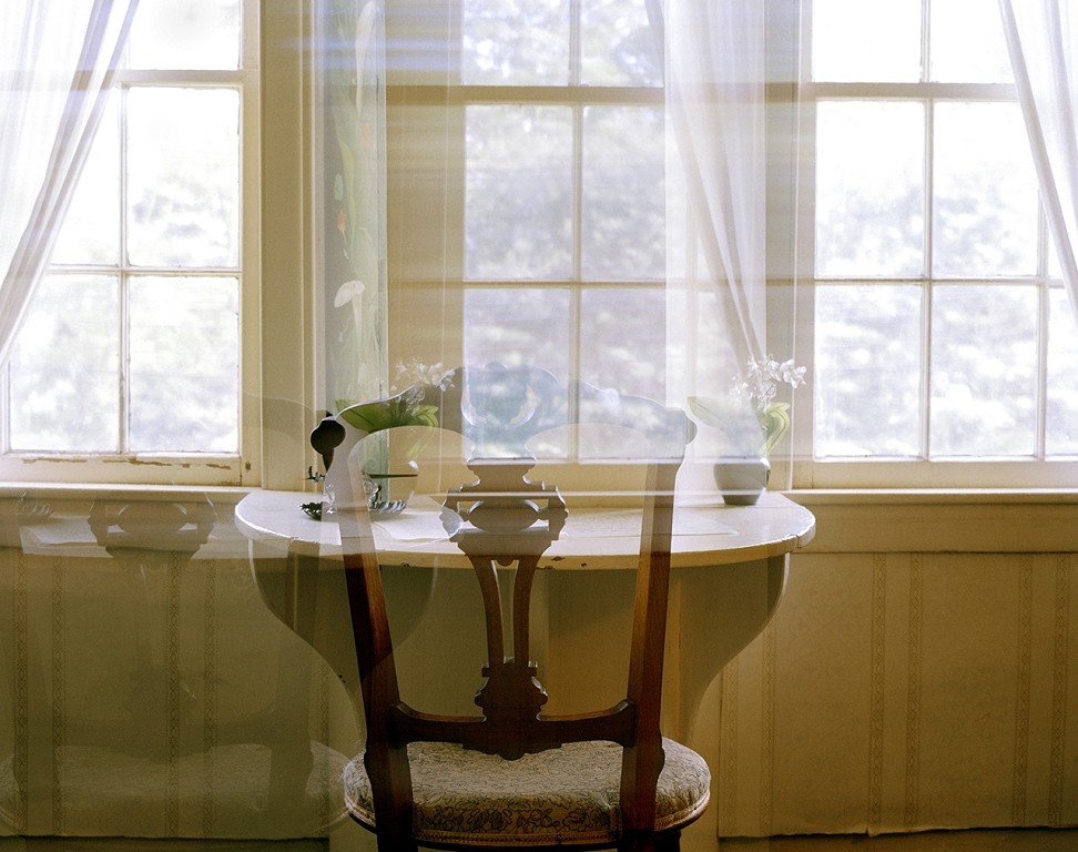  A chair and table with window reflections. 