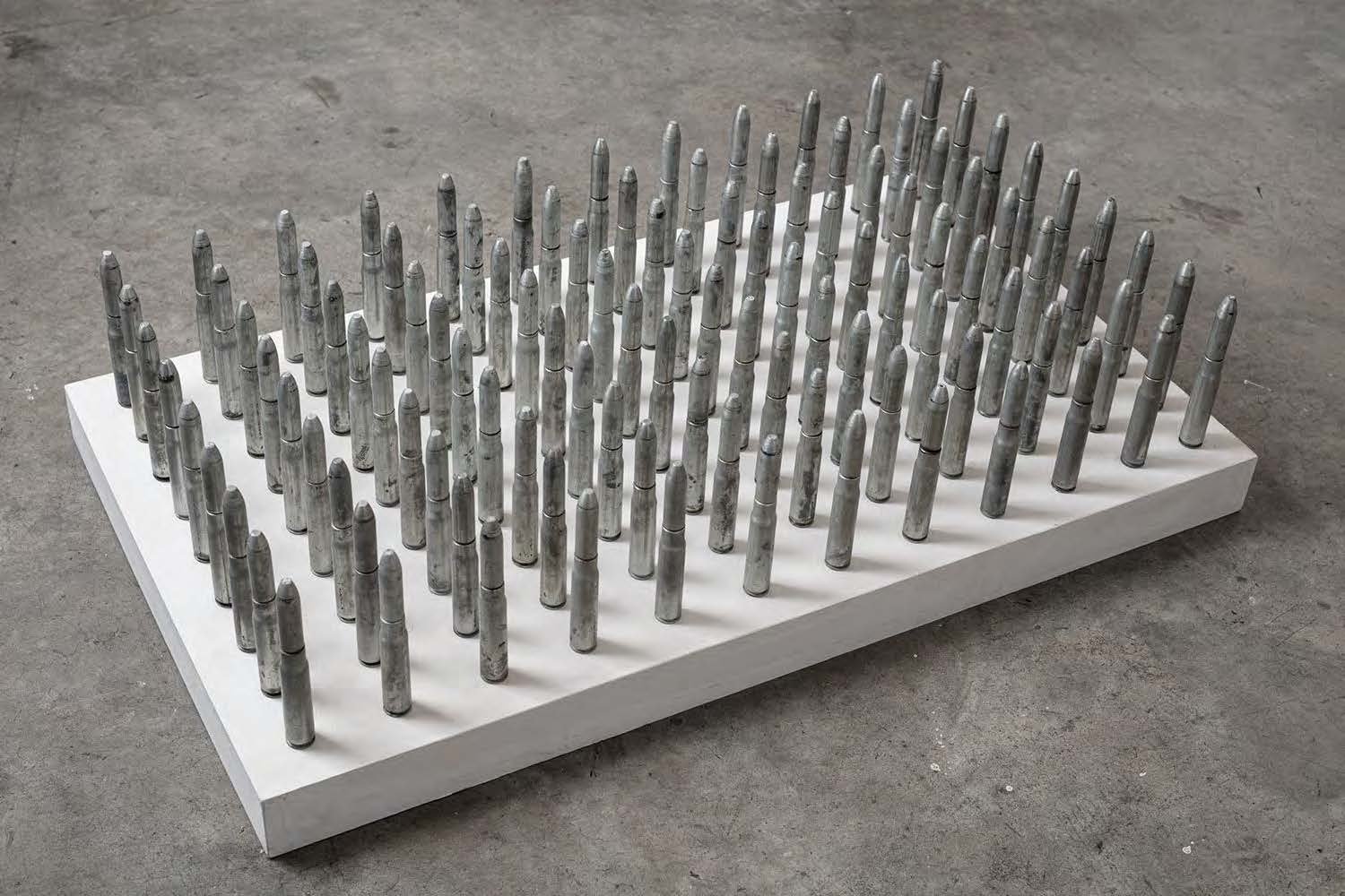  Rows of anti-aircraft bullets on a white platform. 