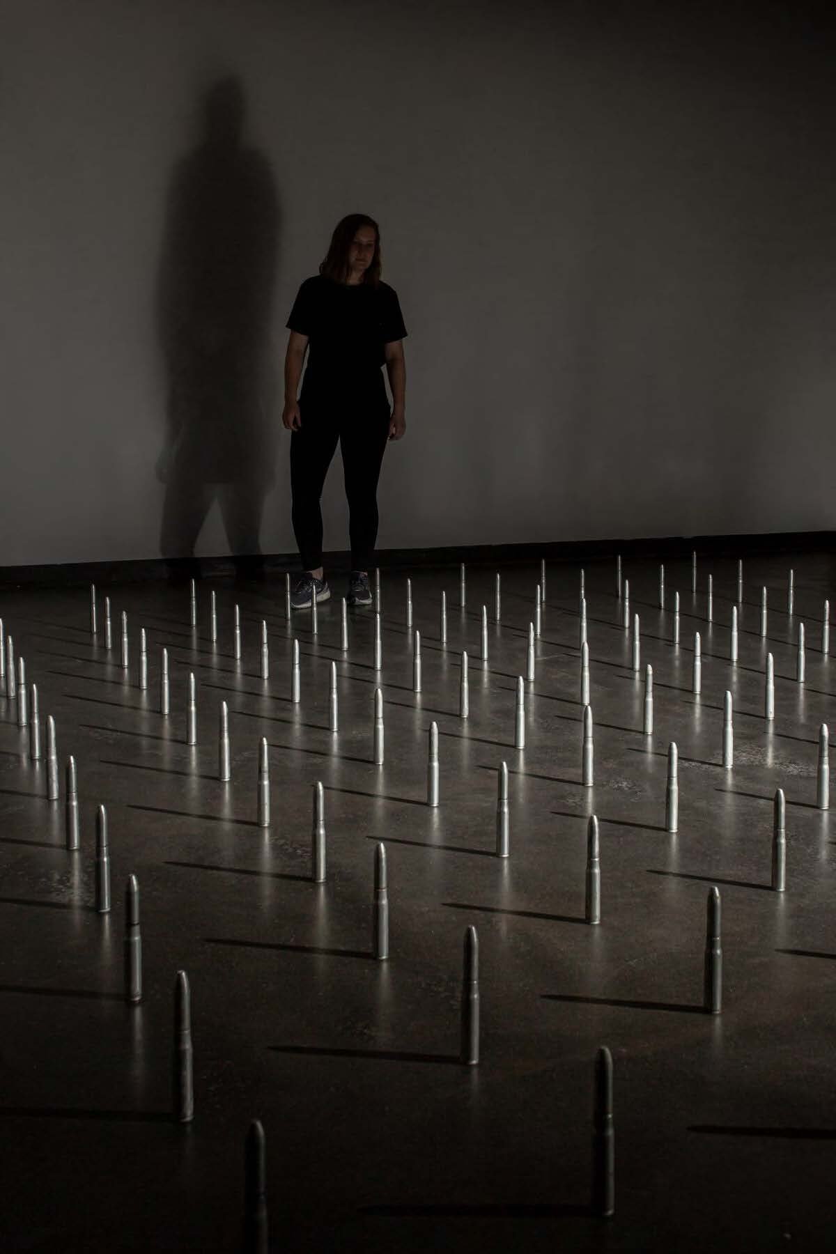  Individual looks out on rows of 20mm anti-aircraft bullets. 