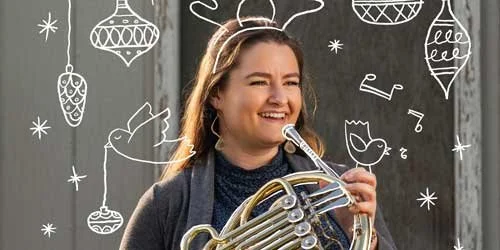 A person smiling while holding a French horn with festive white doodles of reindeer antlers, musical notes, birds, and hanging ornaments surrounding them.