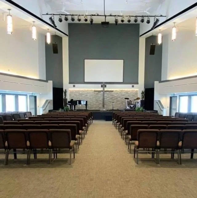 The interior of the Okotoks Alliance Church showing the stage, musical equipment, and audience seating.