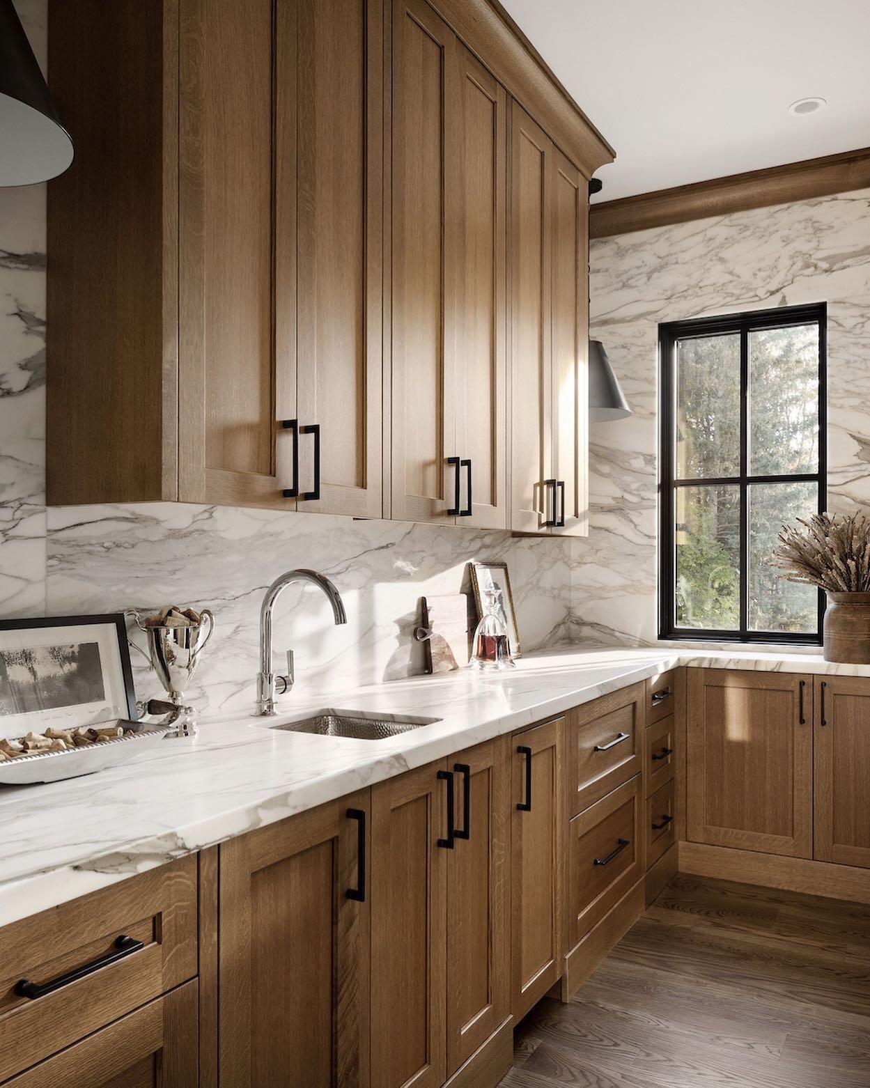 Our butler's pantry is just off of our kitchen, making it the perfect spot to shake up those martinis when we are entertaining. 
The rift-cut oak cabinetry is paired with marble that extends up the walls taking center stage. 
Behind cabinetry are a @