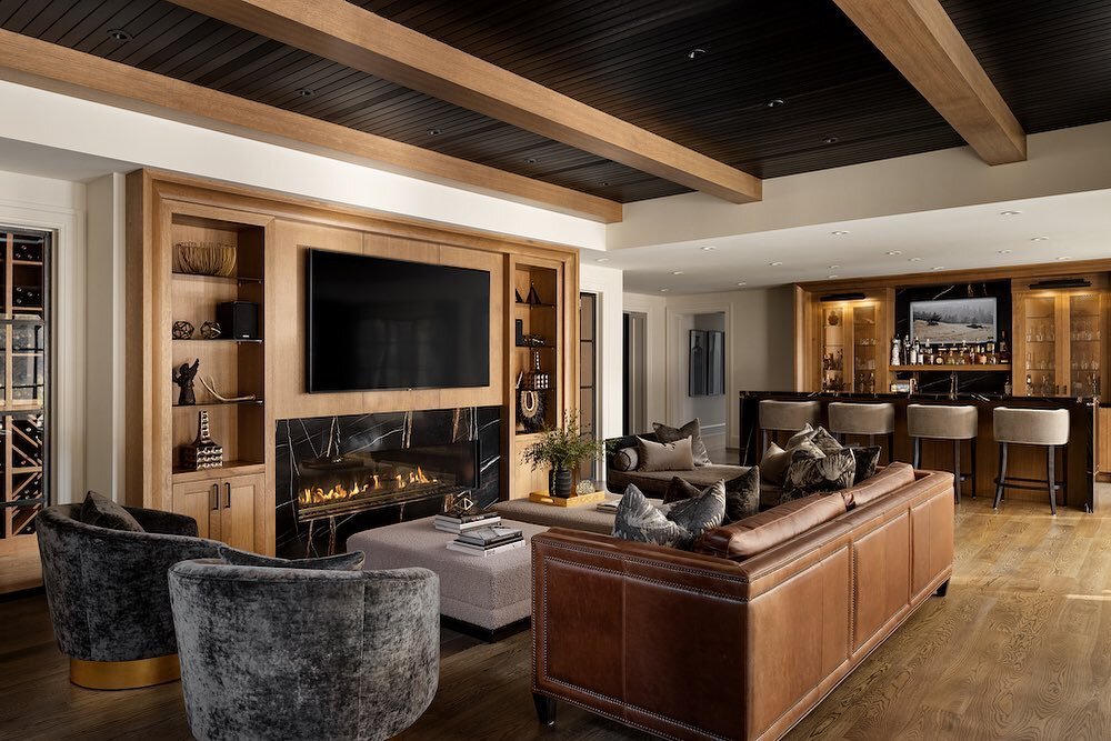 The basement was one space we didn&rsquo;t overlook when designing the home. We wanted it to be a fun hangout spot that has something for everyone. 
The wine cellar extends the fall wall behind the fireplace built-in, a large wet bar with seating for