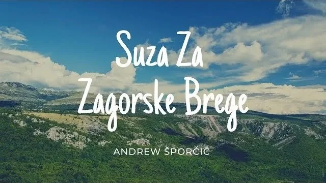 Landscape photo of a green valley with mountains and a blue sky with clouds, overlaid with the text 'Suza Za Zagorske Brege' and 'Andrew Sporcic'.