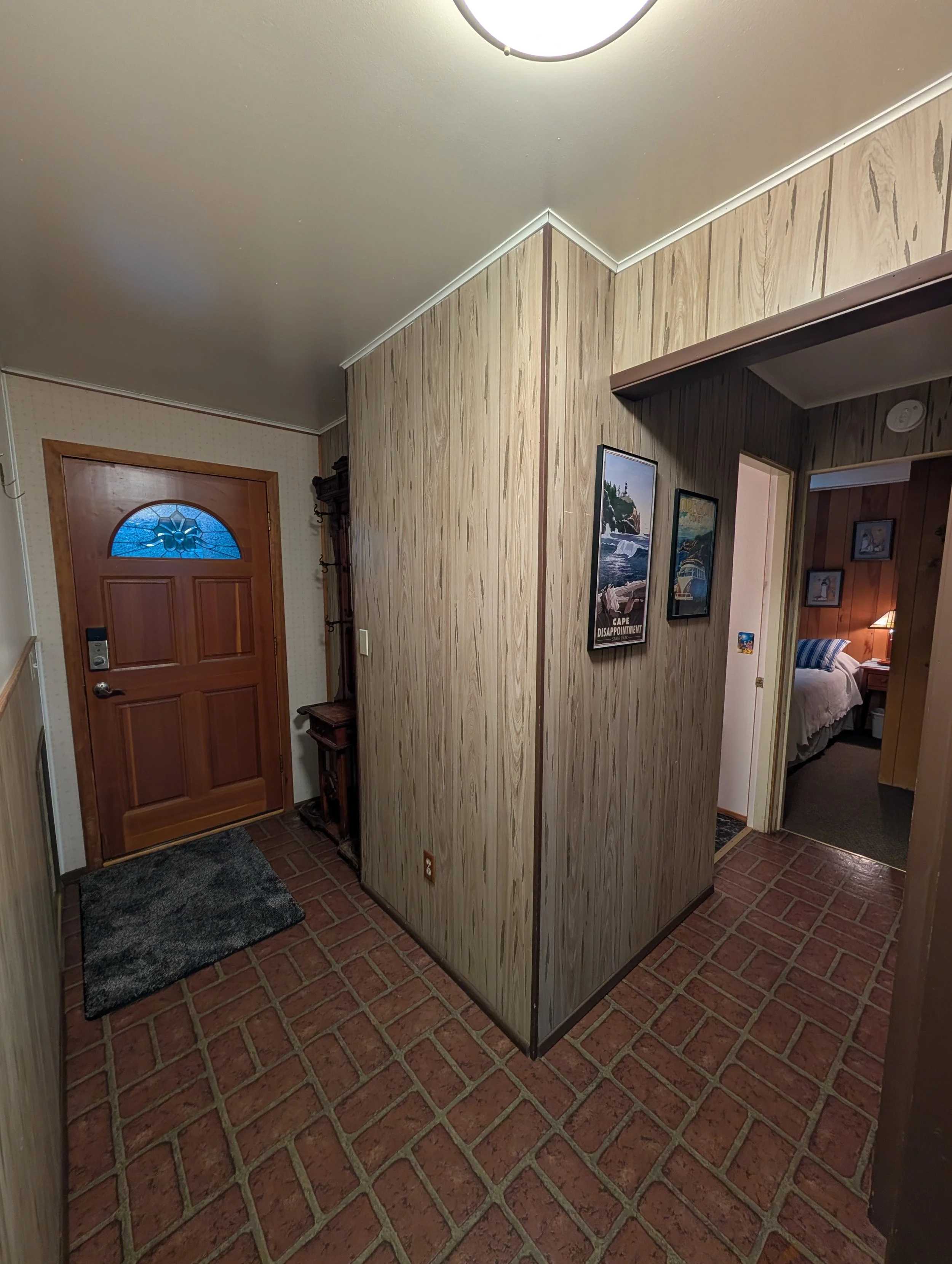 Sea Vista's hallway with access to the front door on the left, and hallway to the queen bedroom and bathroom to the right. 

(Image taken on 11/5/2025 using 0.5x magnification)
