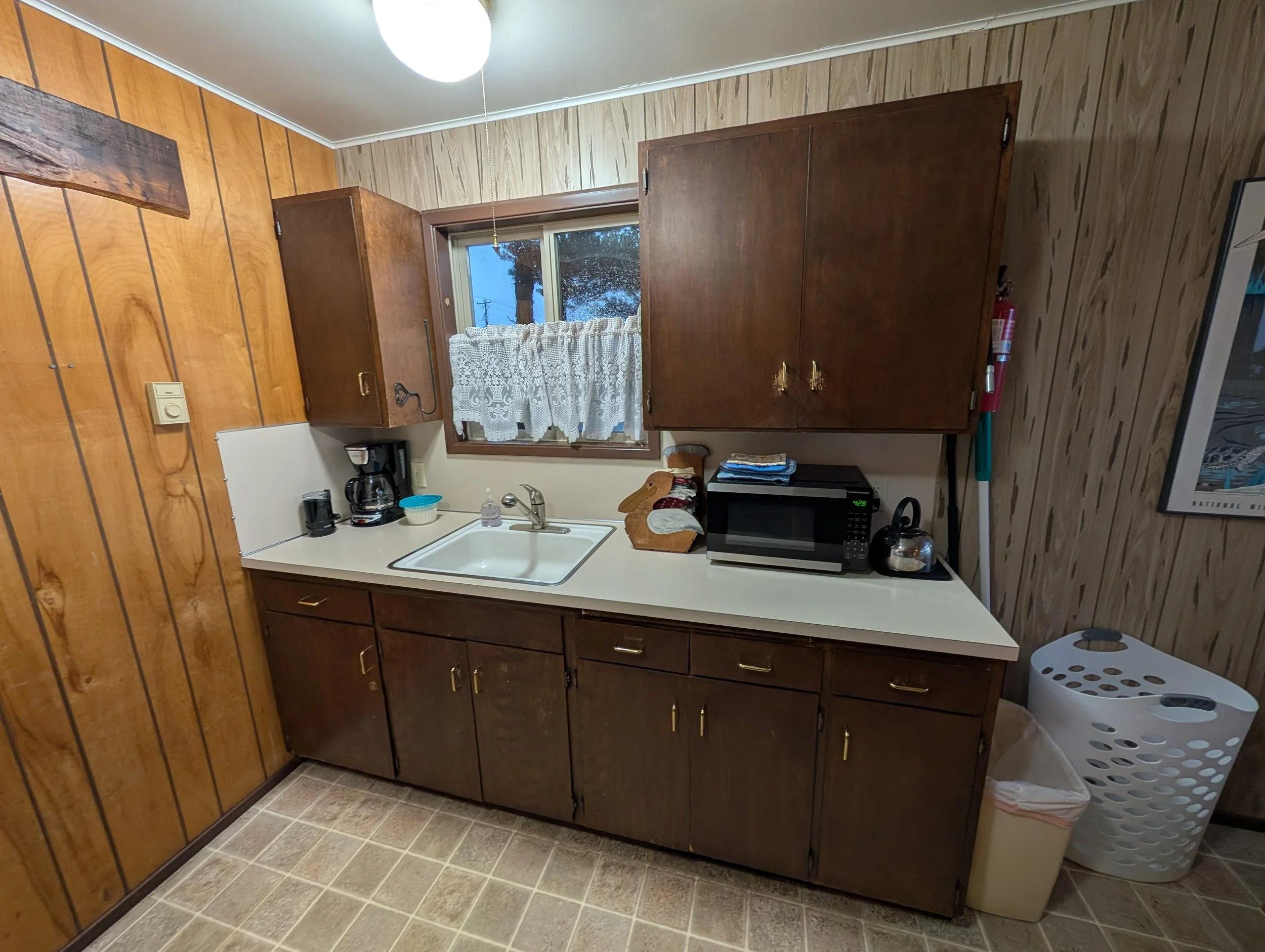 Sea Vista's kitchen facing southeast-ish. 

There is a coffee maker (and coffee filters in a little tupperware container), and a microwave. There is also a silver kettle next to the microwave. Plates, bowls, glasses, mugs, silverware, knives, pots, p