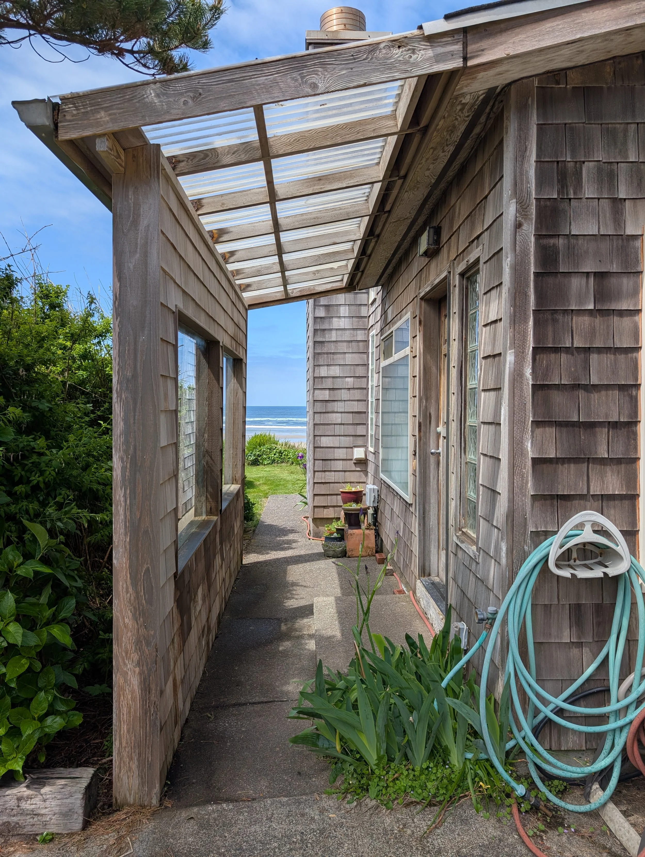 Entrance to the solarium and king bedroom #2 on the south end of building. Westward pathway wraps around the house to the west deck and sliding glass doors to the dining room/kitchen/living room.

(Image taken 5/8/2026)
