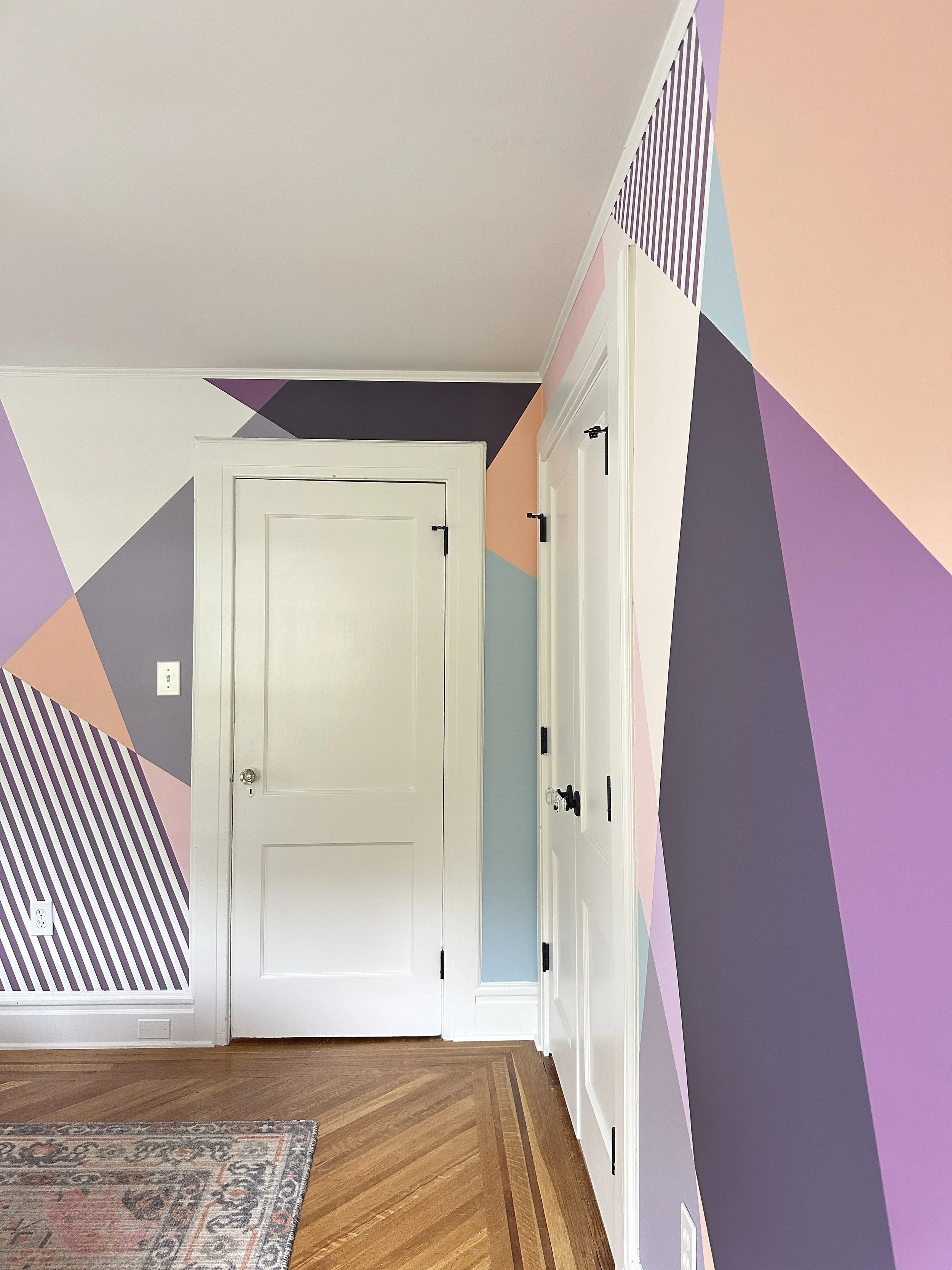 Colorful teen girl’s bedroom mural with playful geometric shapes wrapping around the room for a warm, creative feel.