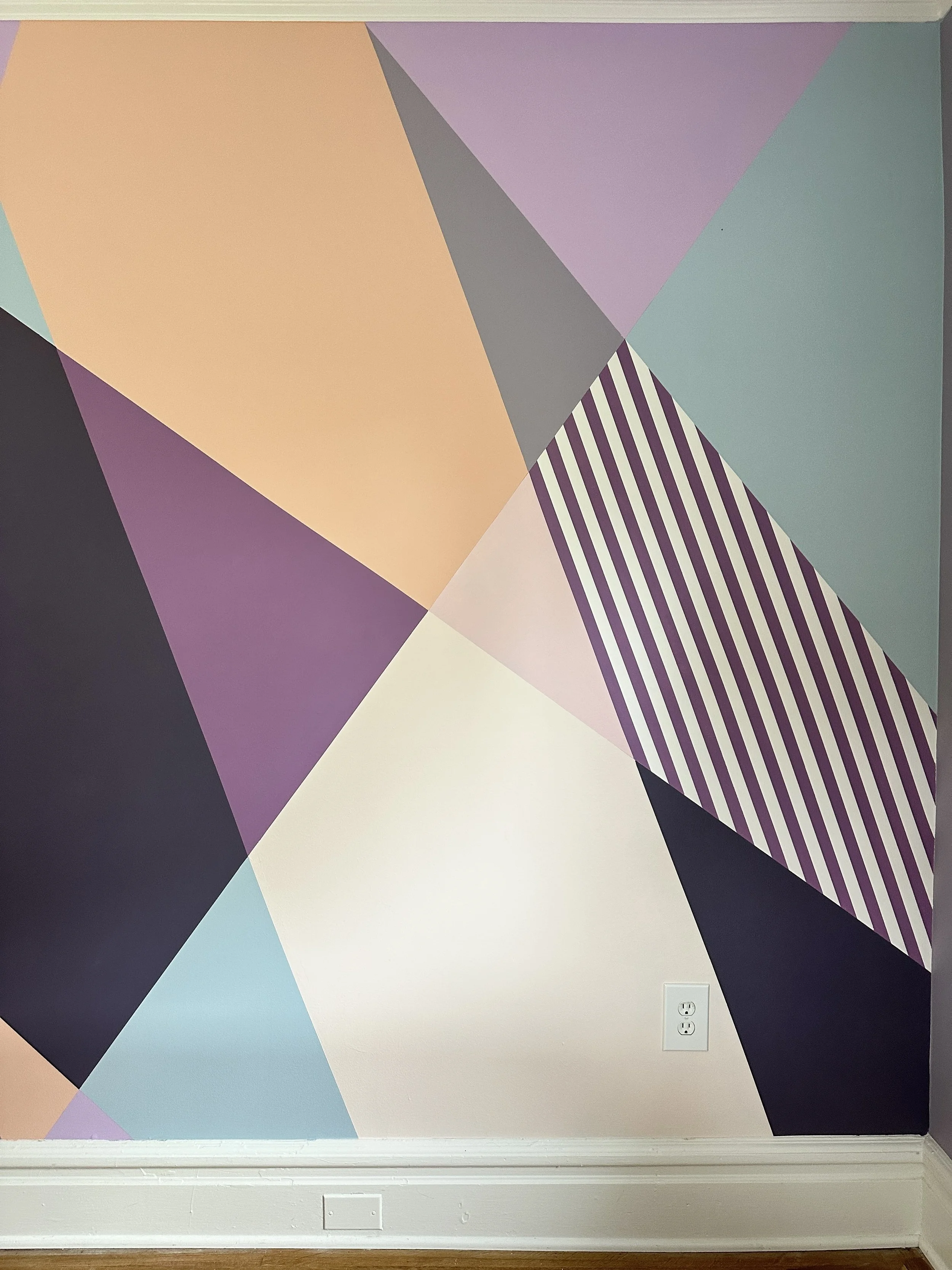Playful geometric mural in a teen bedroom, using painted shapes and color to create a cozy retreat-like space.