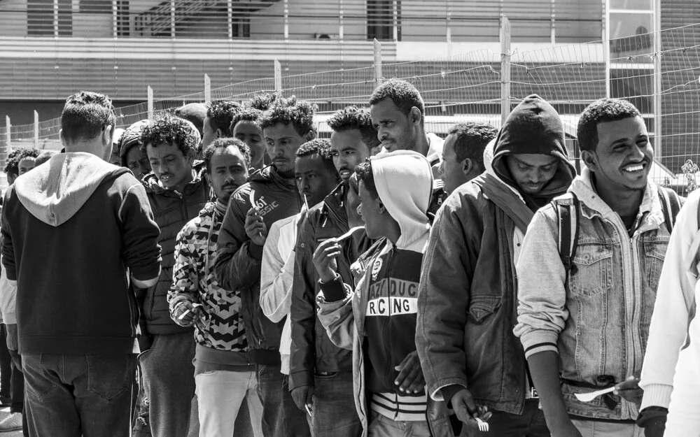   Meal Time   Refugees line up for a meal provided by volunteers in Rome 