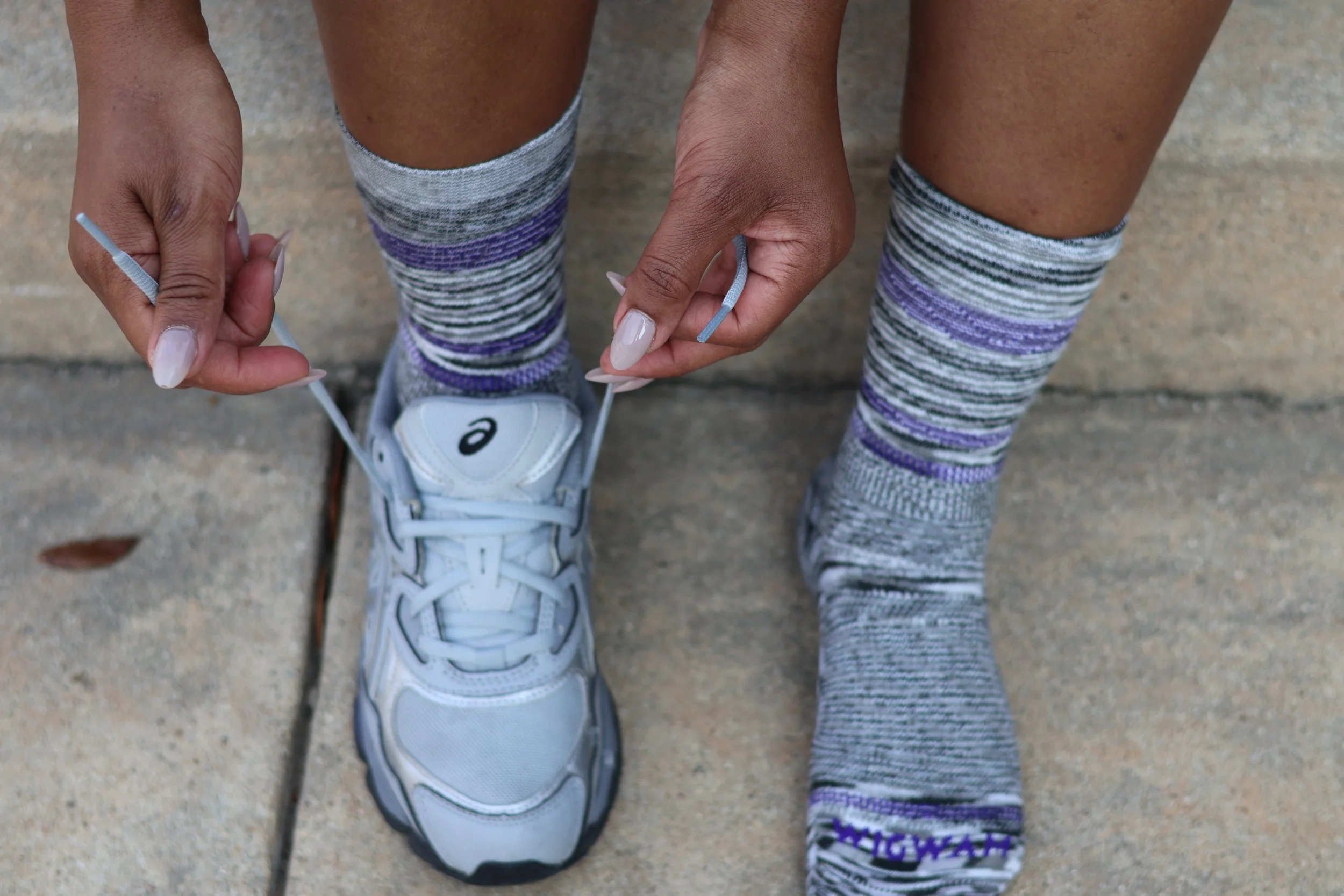 Homeschool mom adjusting sneakers while wearing Wigwam socks