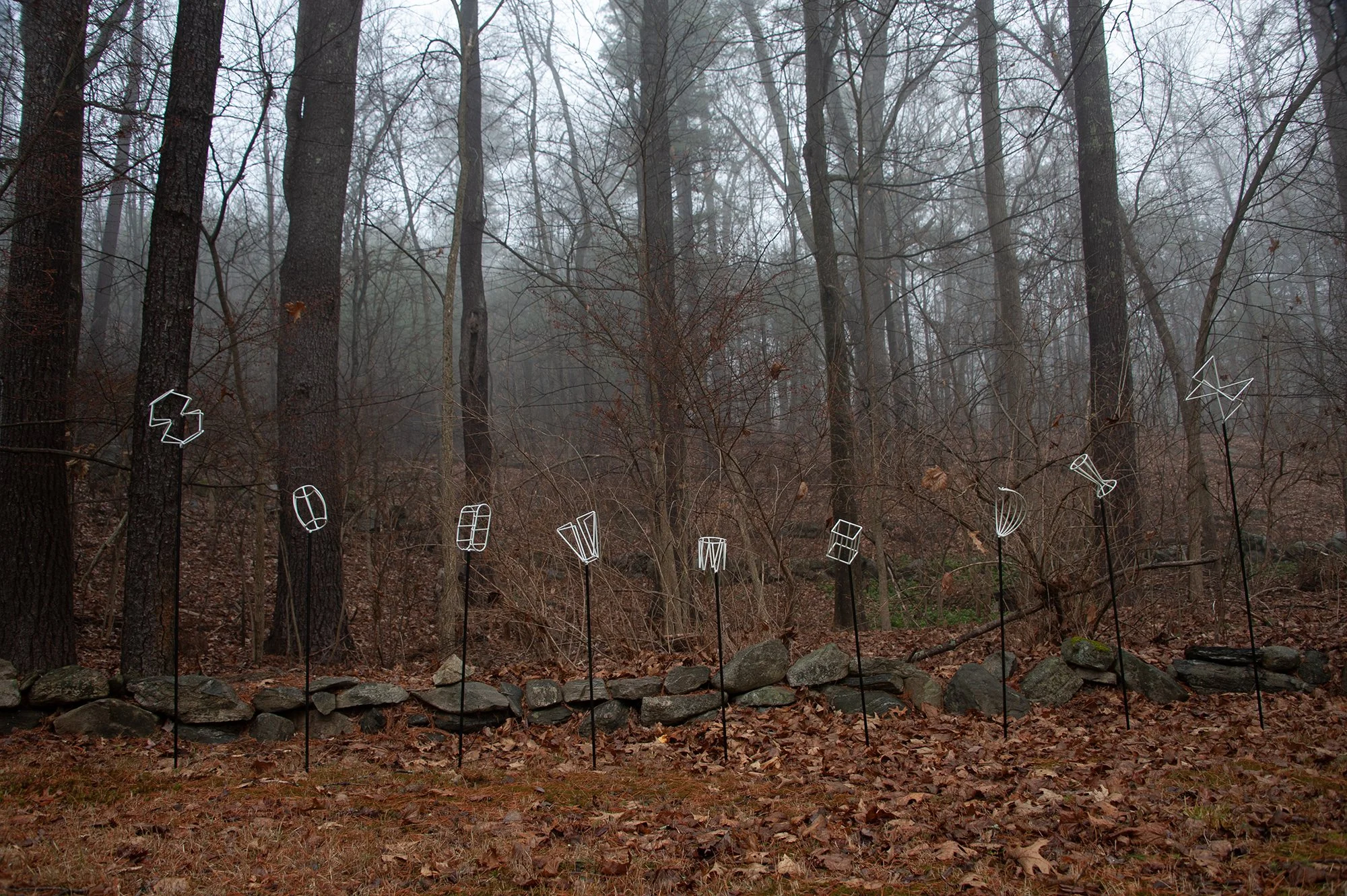 outdoor installation of white, abstract metal sculptures in the fall